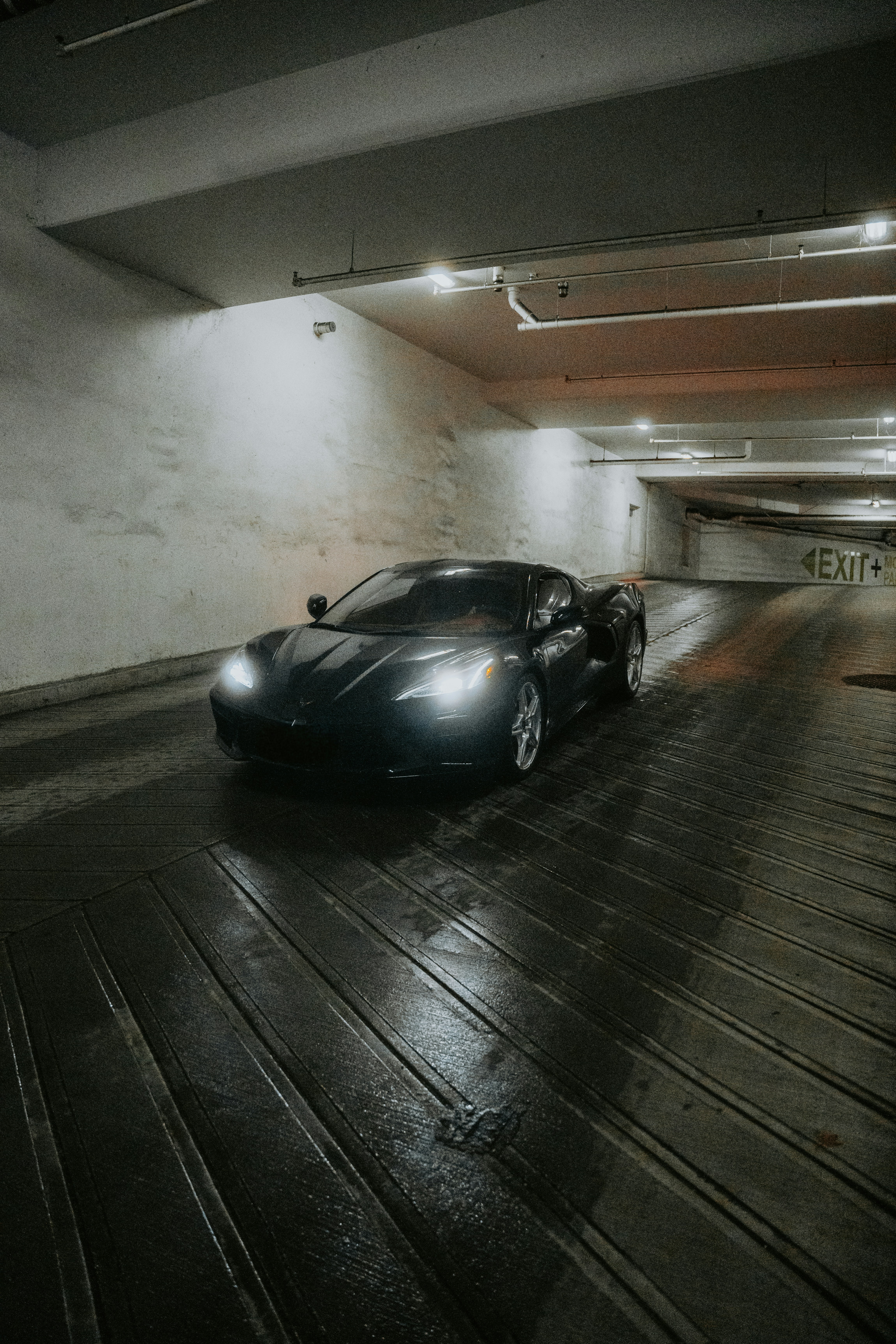 A black sports car parked in a parking garage