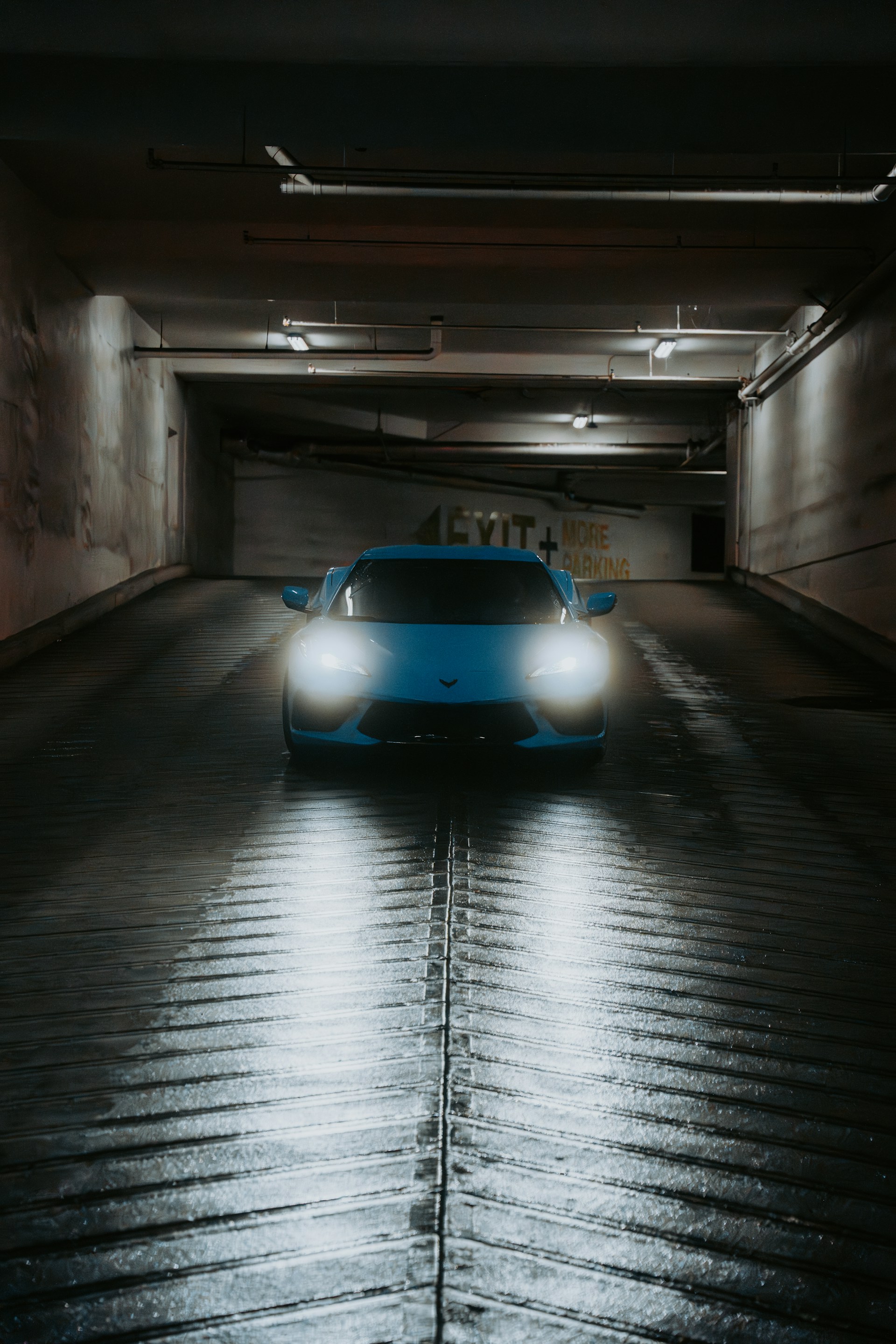 A blue sports car driving through a tunnel