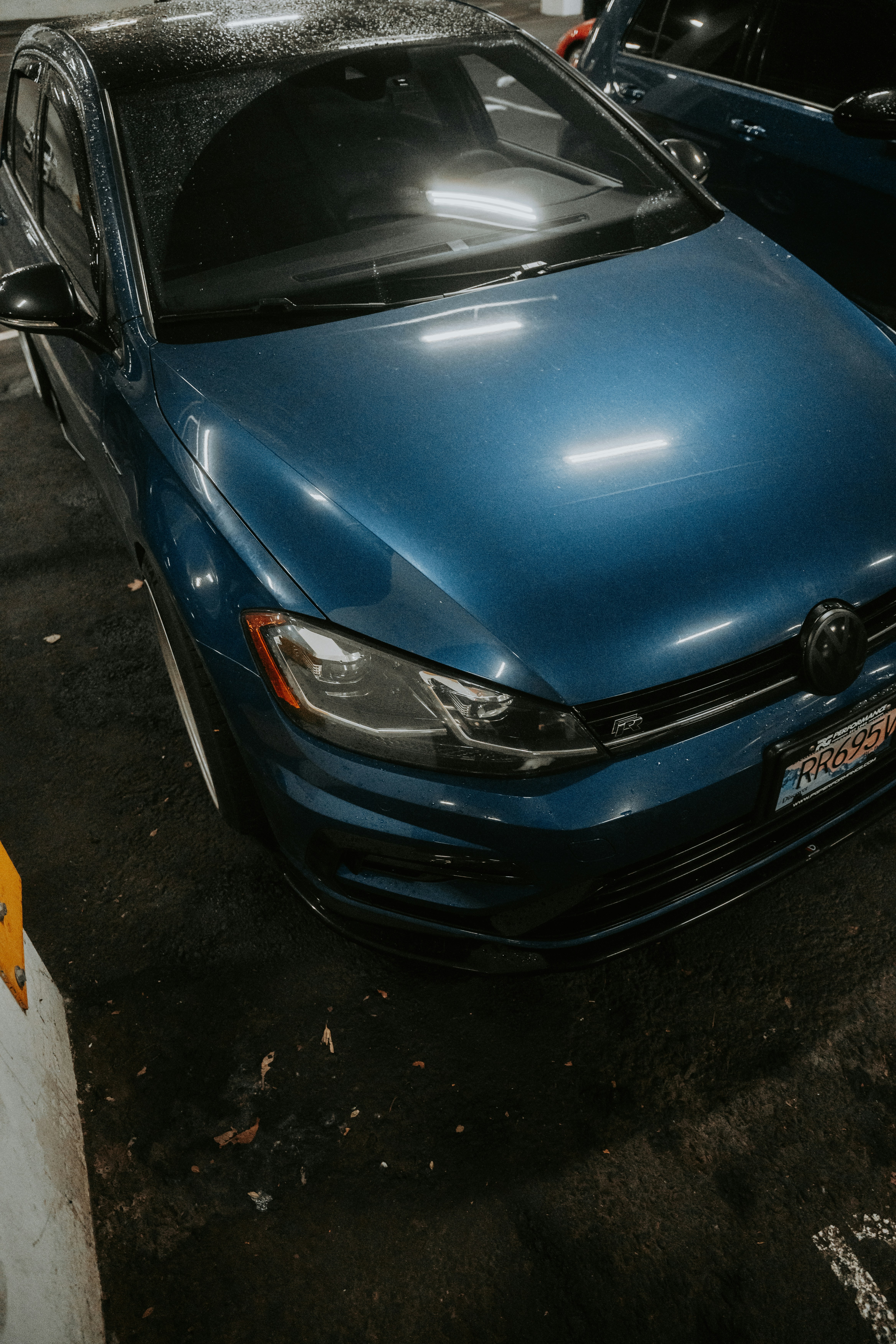 A blue car is parked in a parking lot