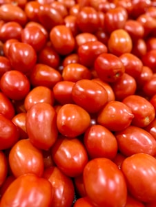 A pile of tomatoes sitting on top of a table
