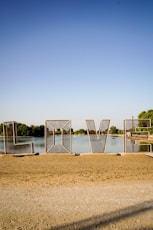 A large metal sculpture sitting on top of a sandy beach