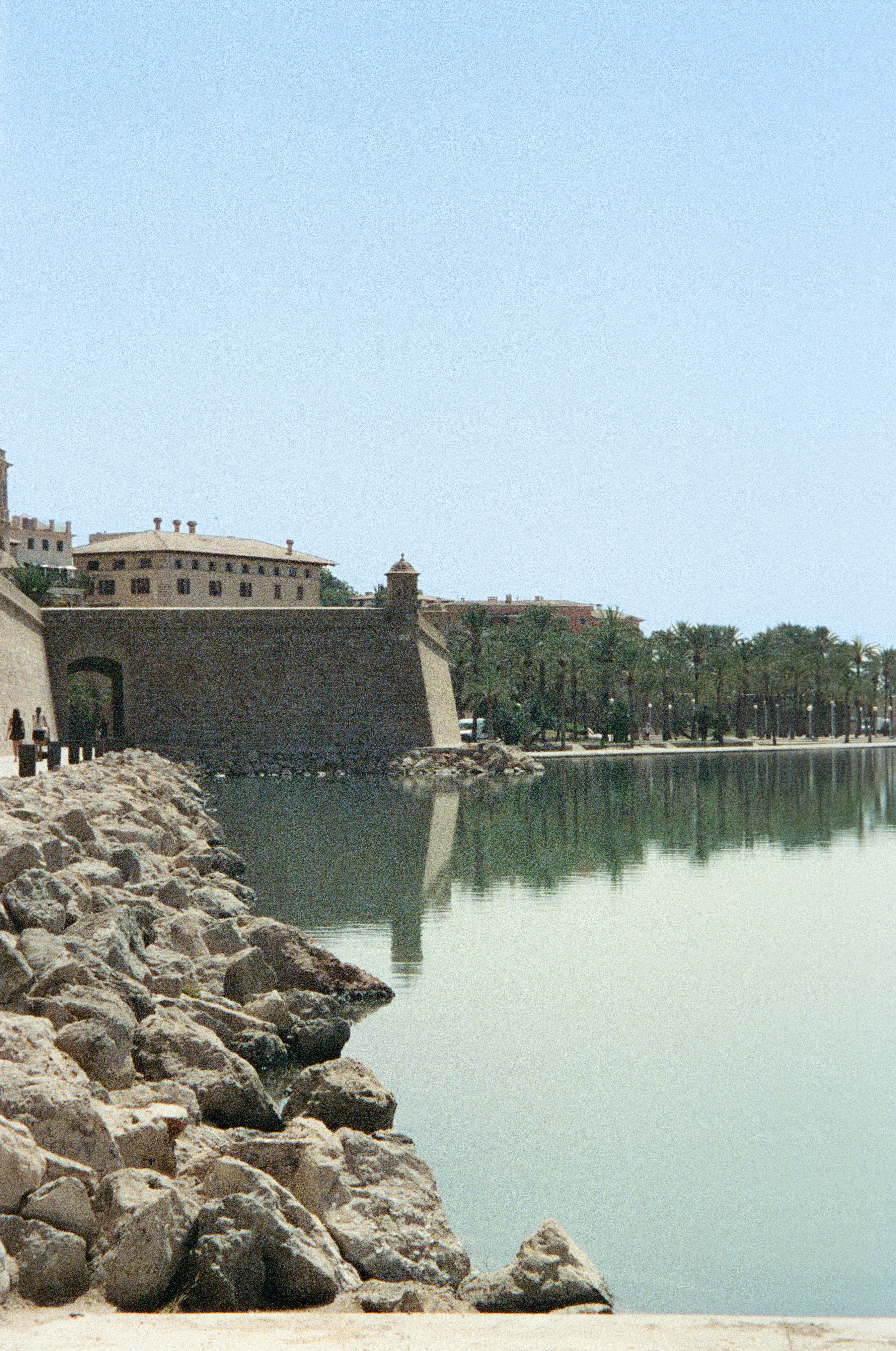 A large body of water next to a stone wall