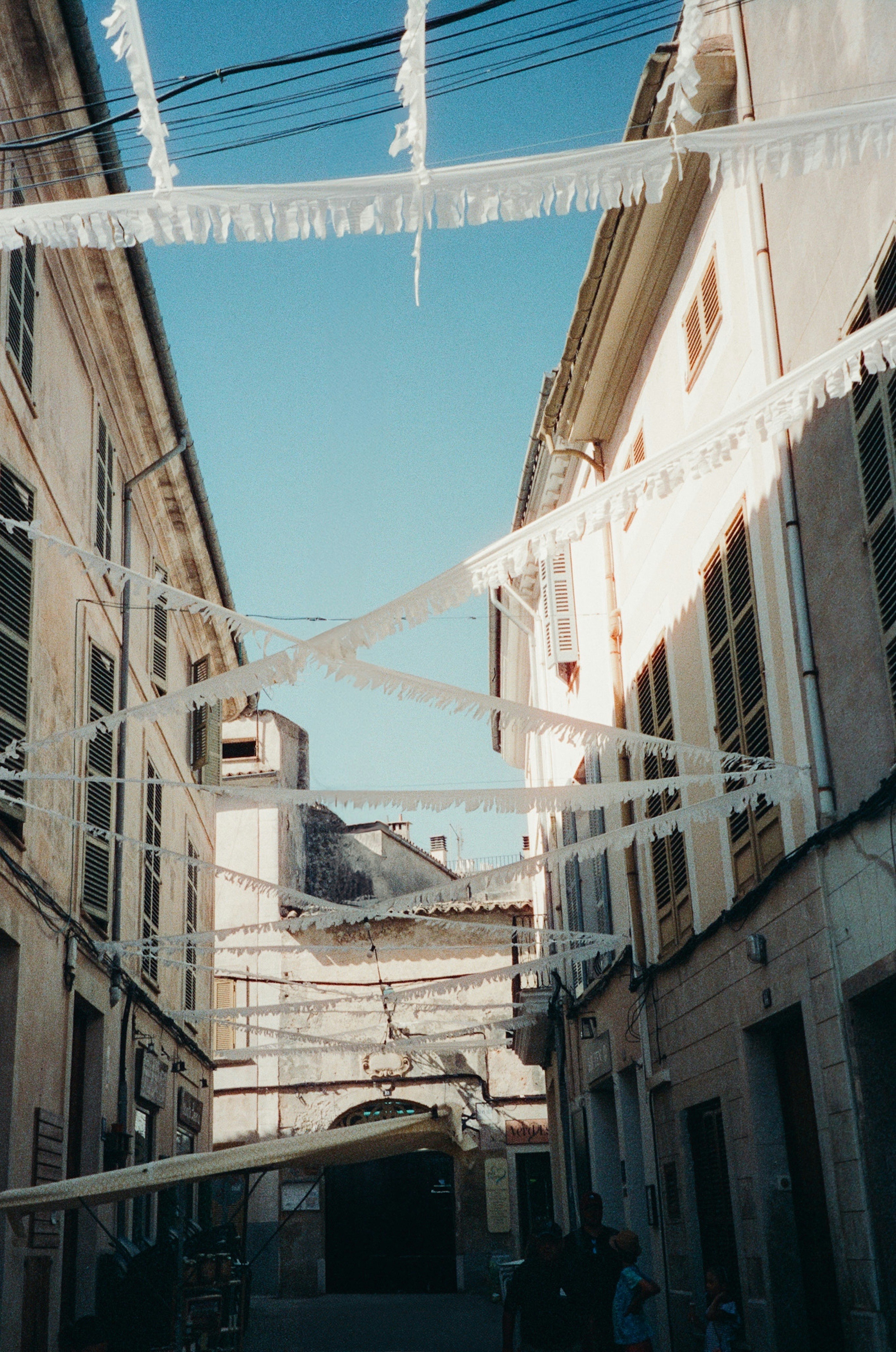 A narrow alleyway with a few people walking down it
