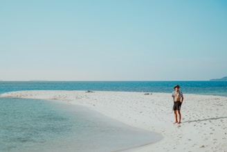 A person walking on a beach near the ocean