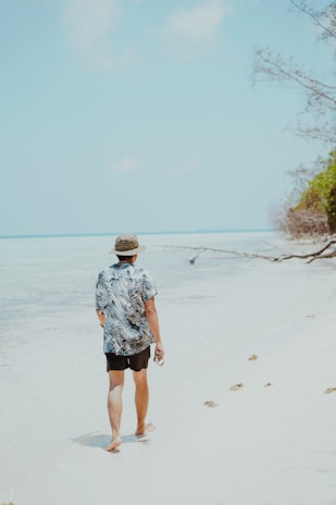A man walking along a beach next to the ocean
