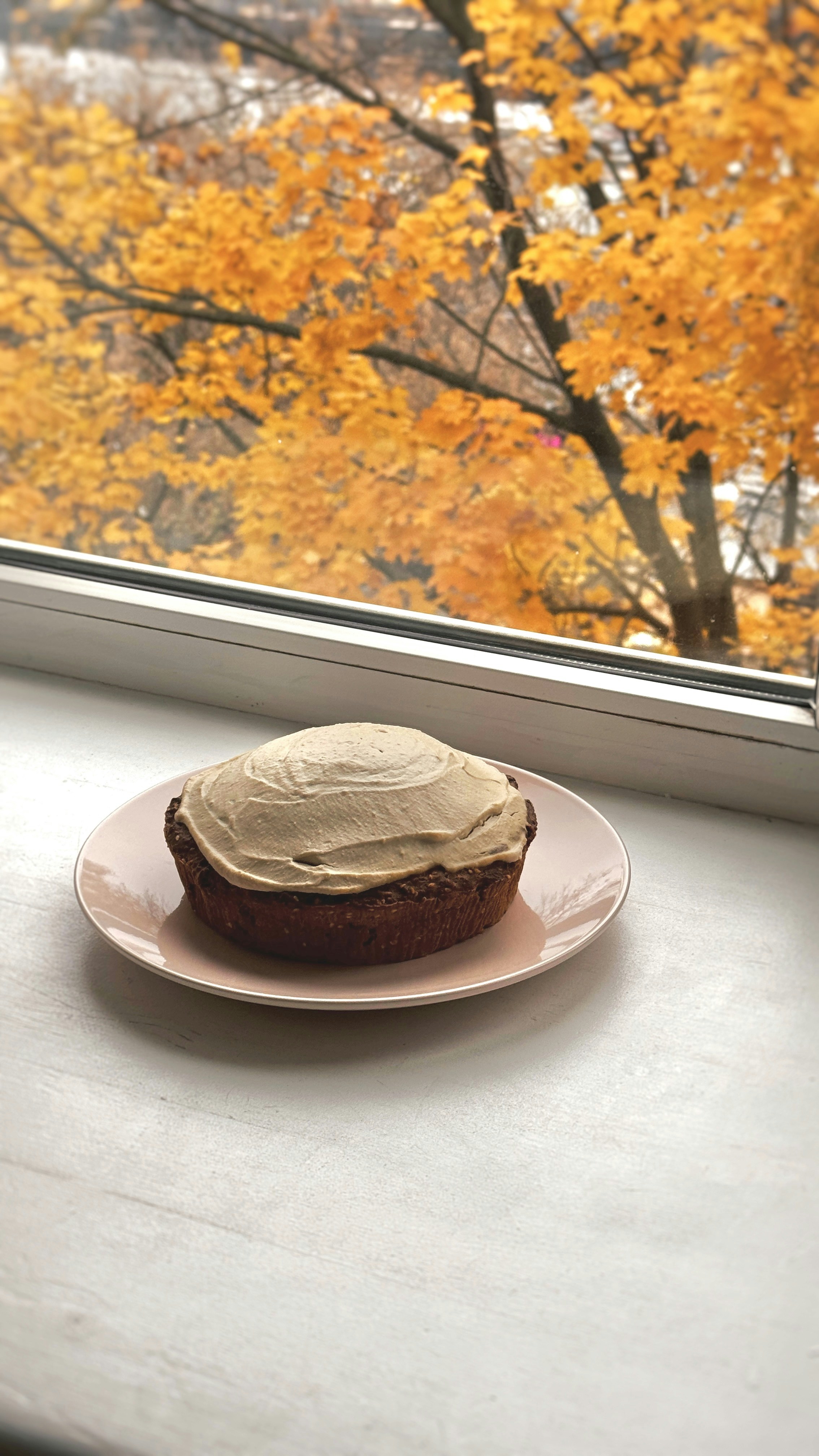 A piece of cake sitting on a plate on a window sill
