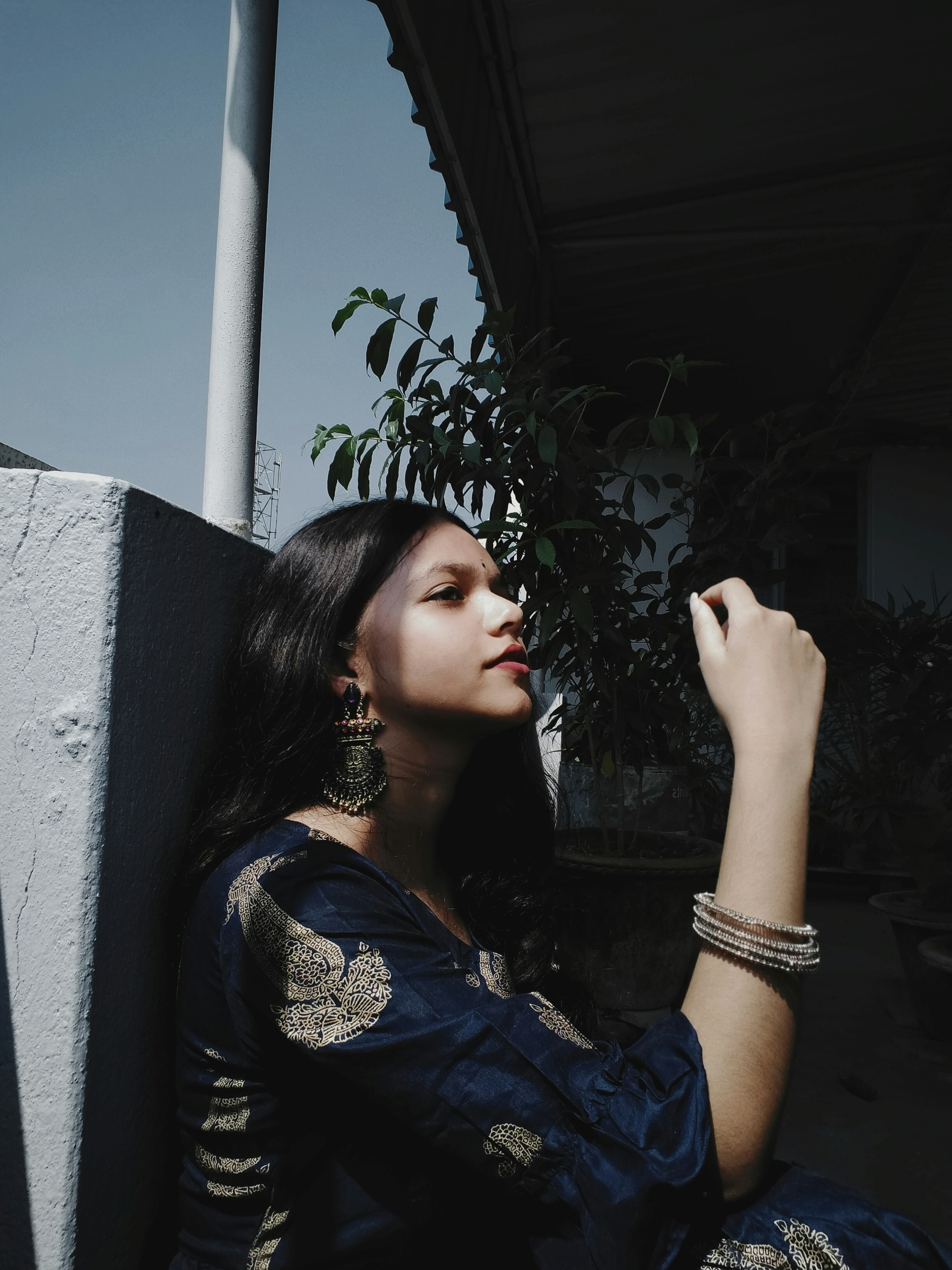 A woman sitting on the ground next to a building