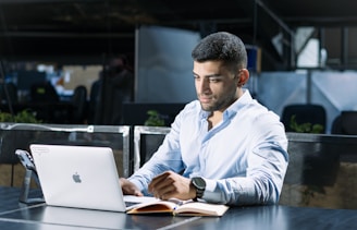 A man sitting at a table using a laptop computer