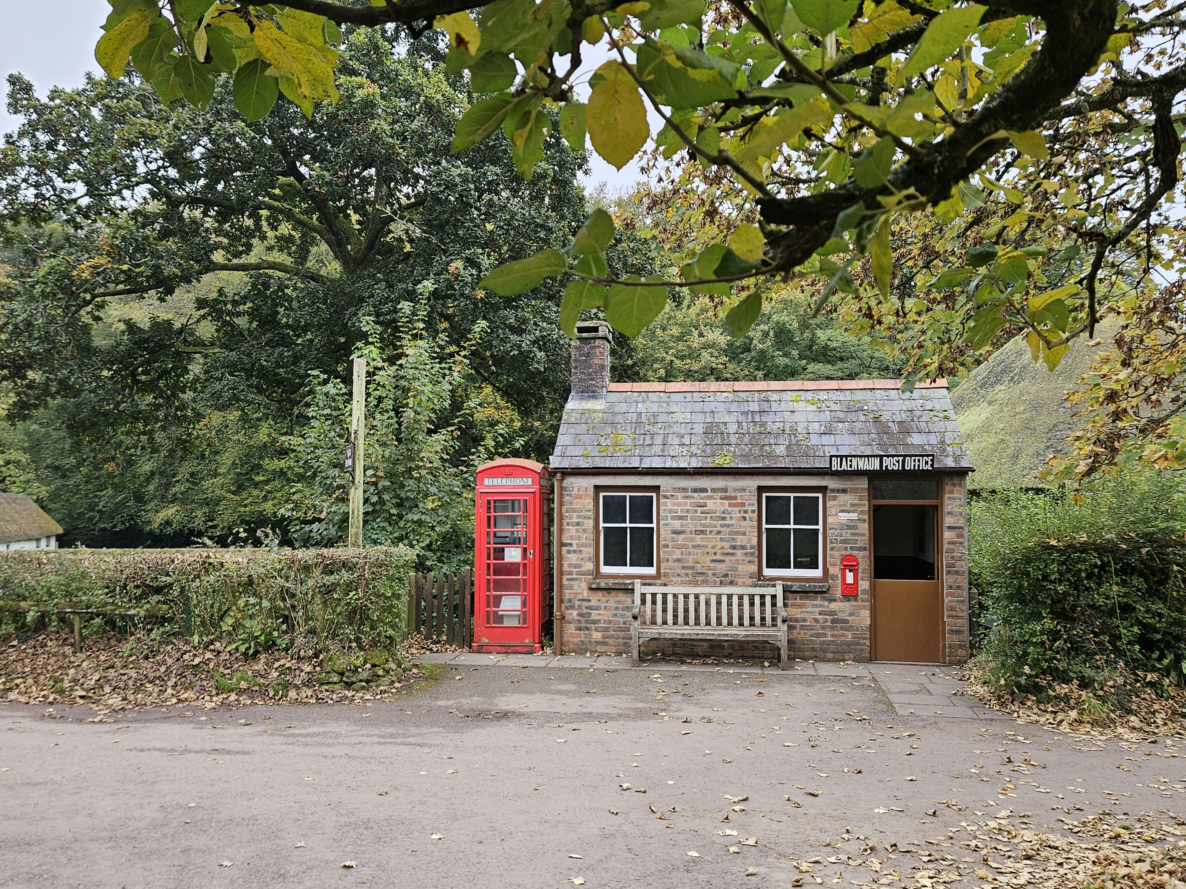 A small brick building with a bench in front of it