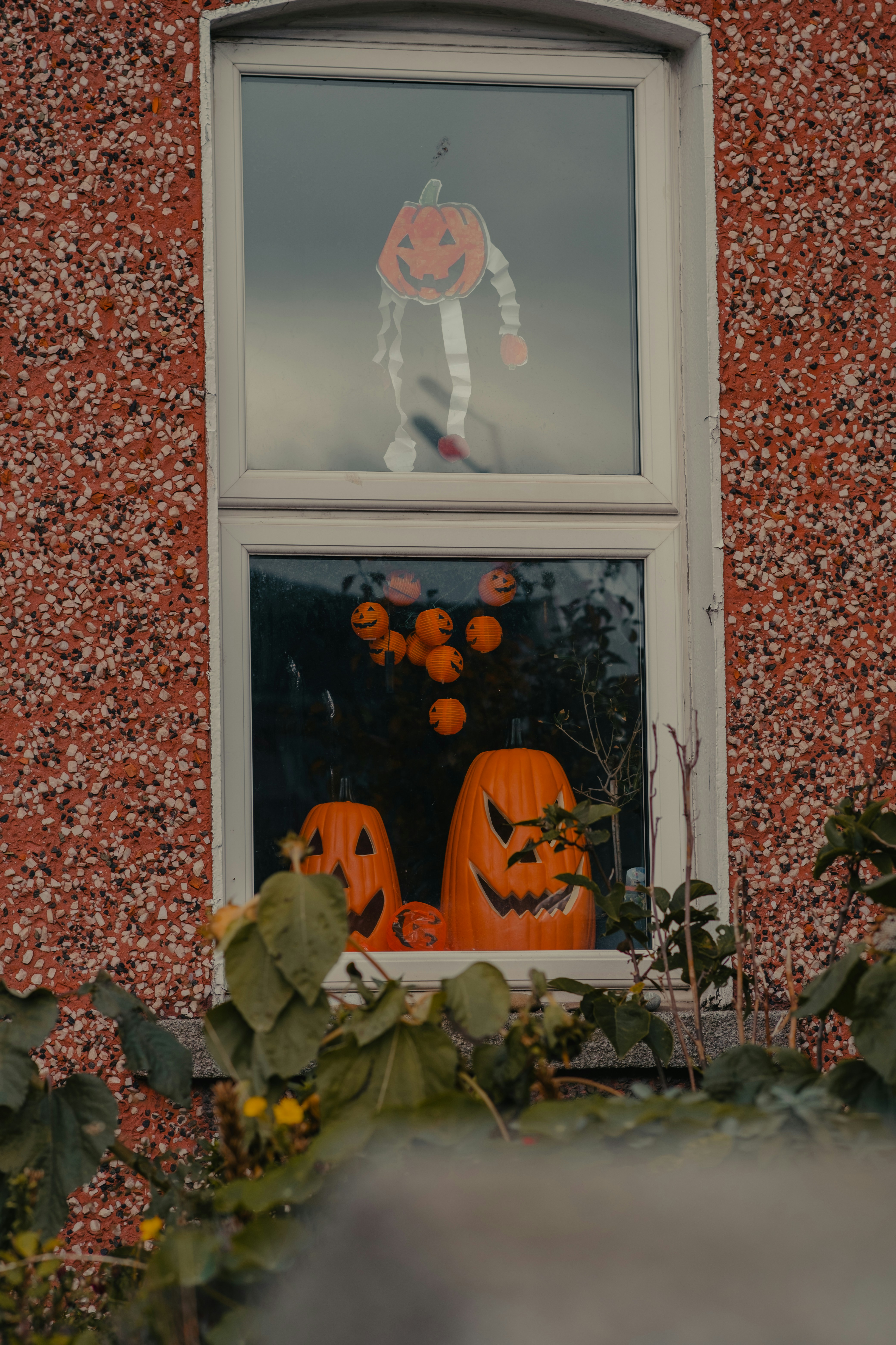 A window decorated with pumpkins and jack - o - lanterns