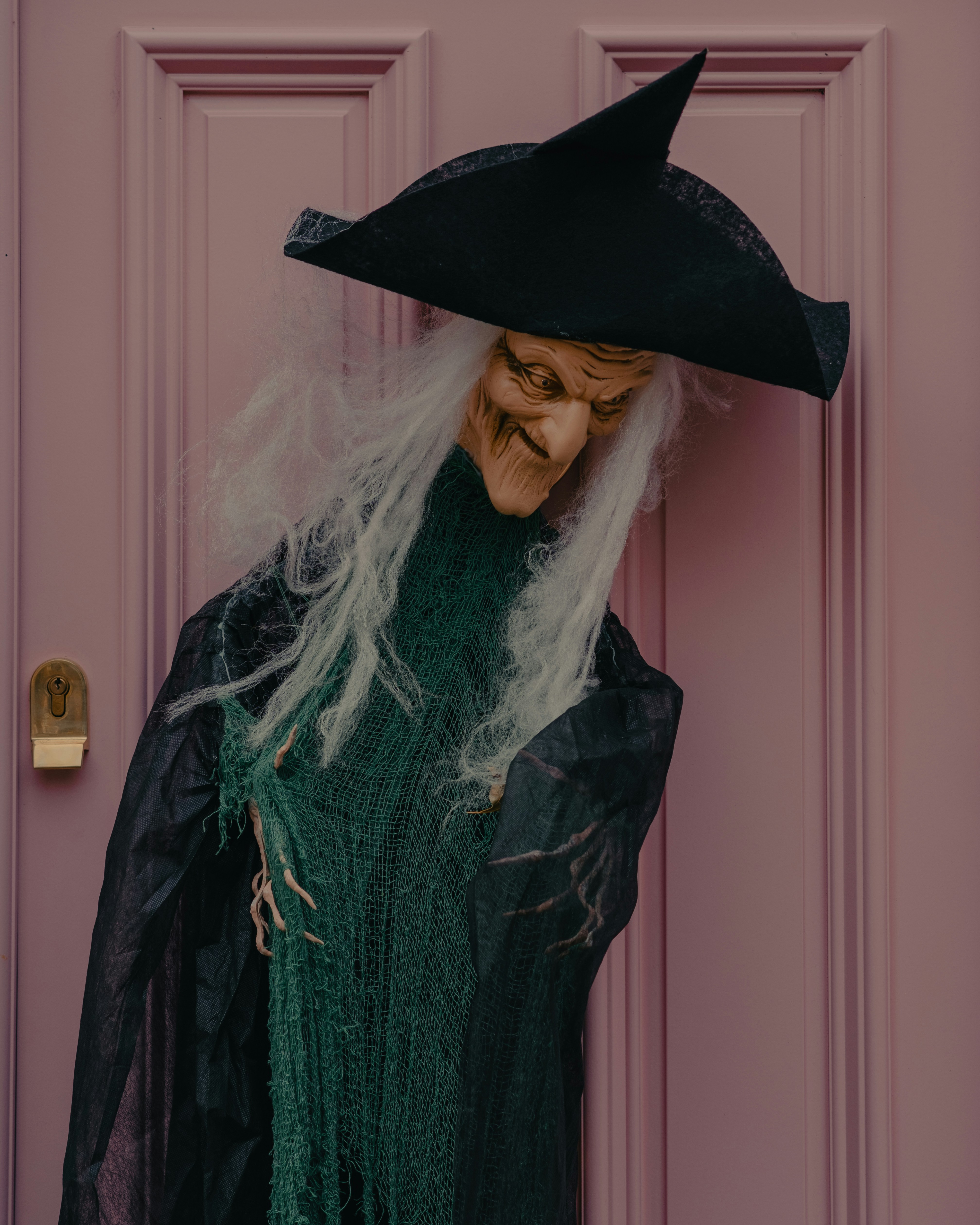A person in a witches costume standing in front of a door