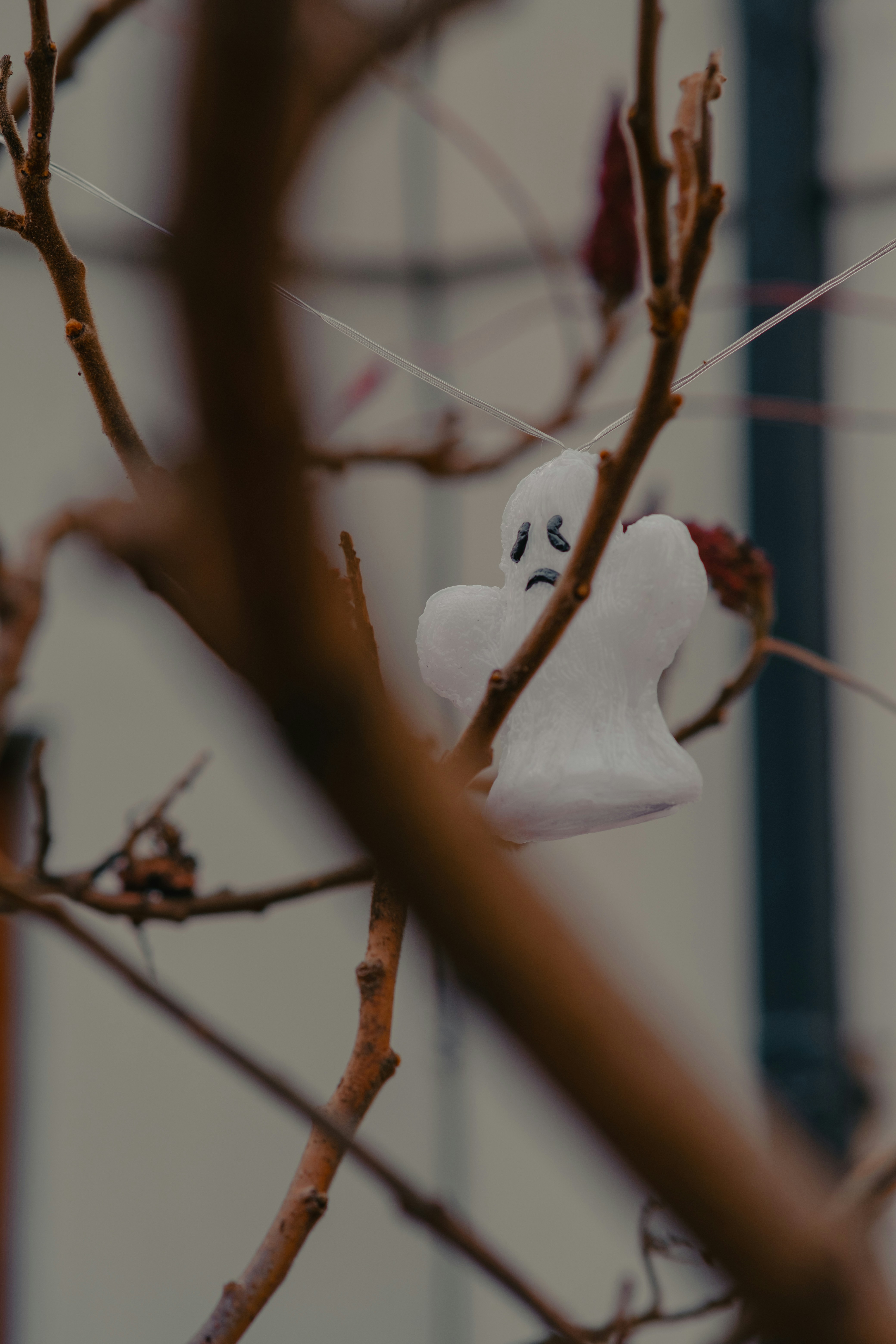 A white ghost hanging from a tree branch
