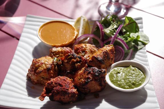 A white plate topped with chicken wings next to a salad