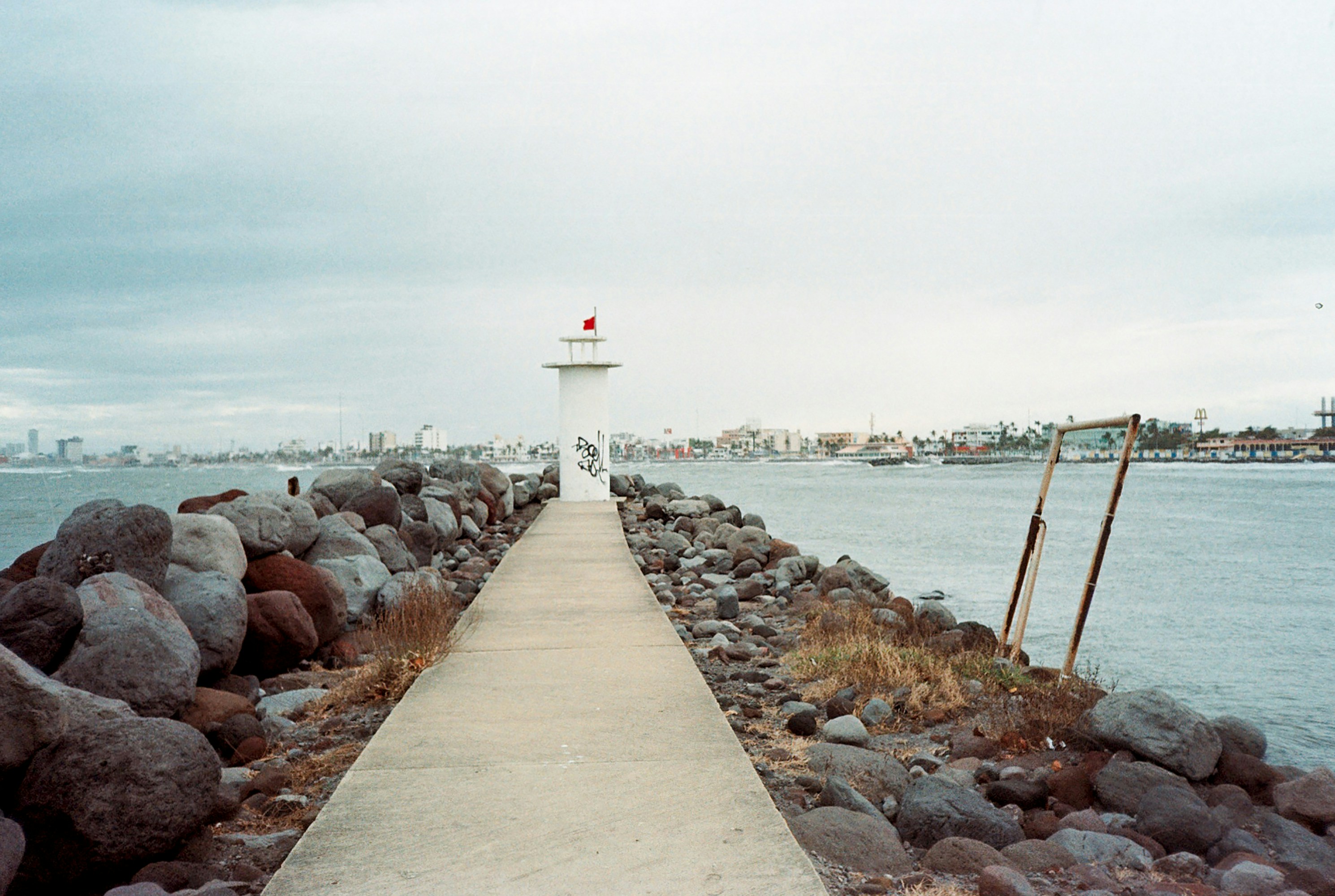 A walkway leading to a lighthouse on a cloudy day