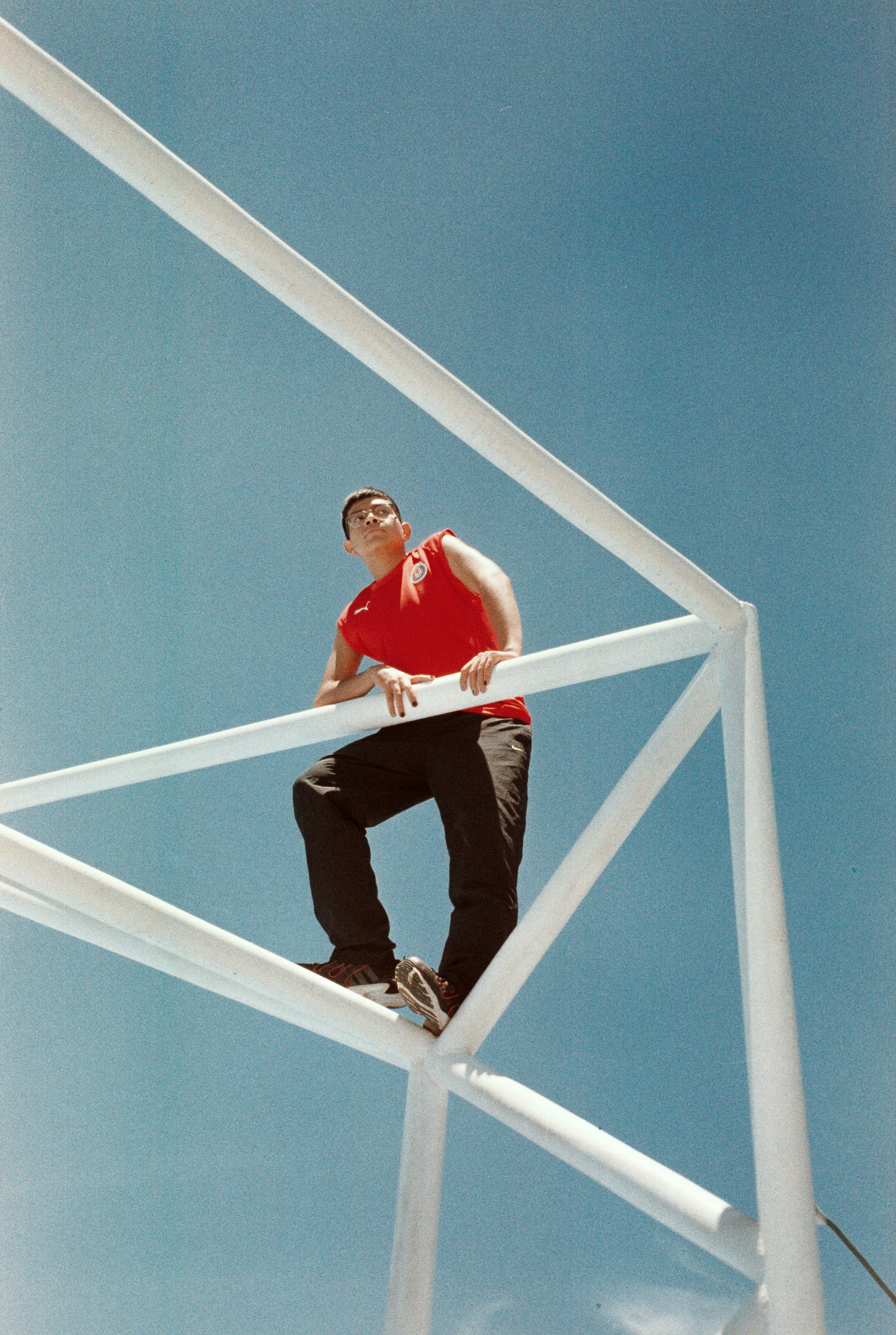 A man in a red shirt is standing on a white structure