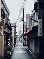 A narrow city street with a person walking down it