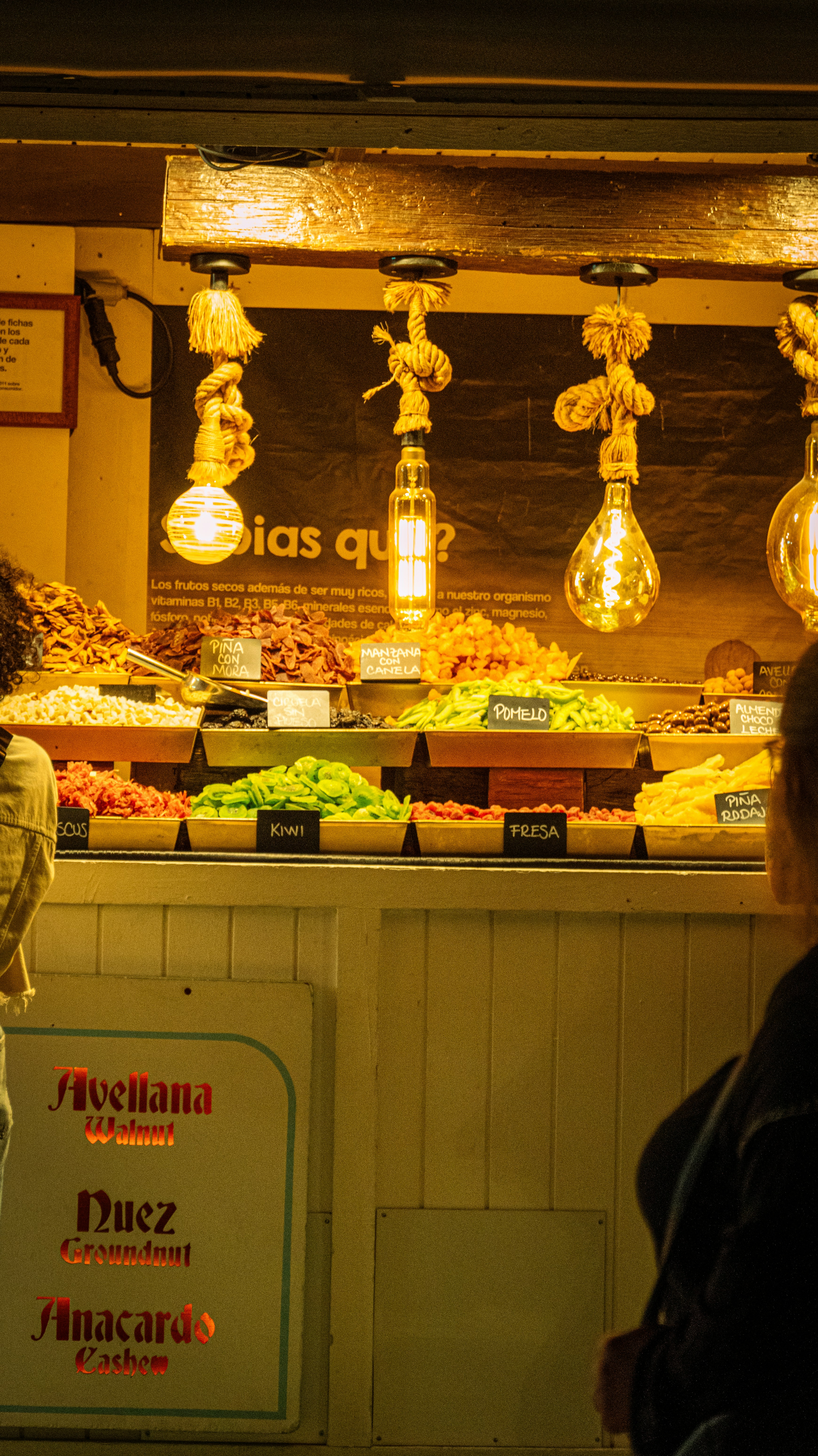 Vibrant food market display with dates, nuts, saffron and avocados, warm natural lighting, rich colors on wooden surface