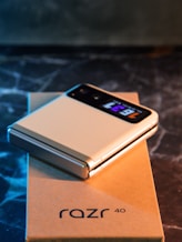 A white cell phone sitting on top of a box