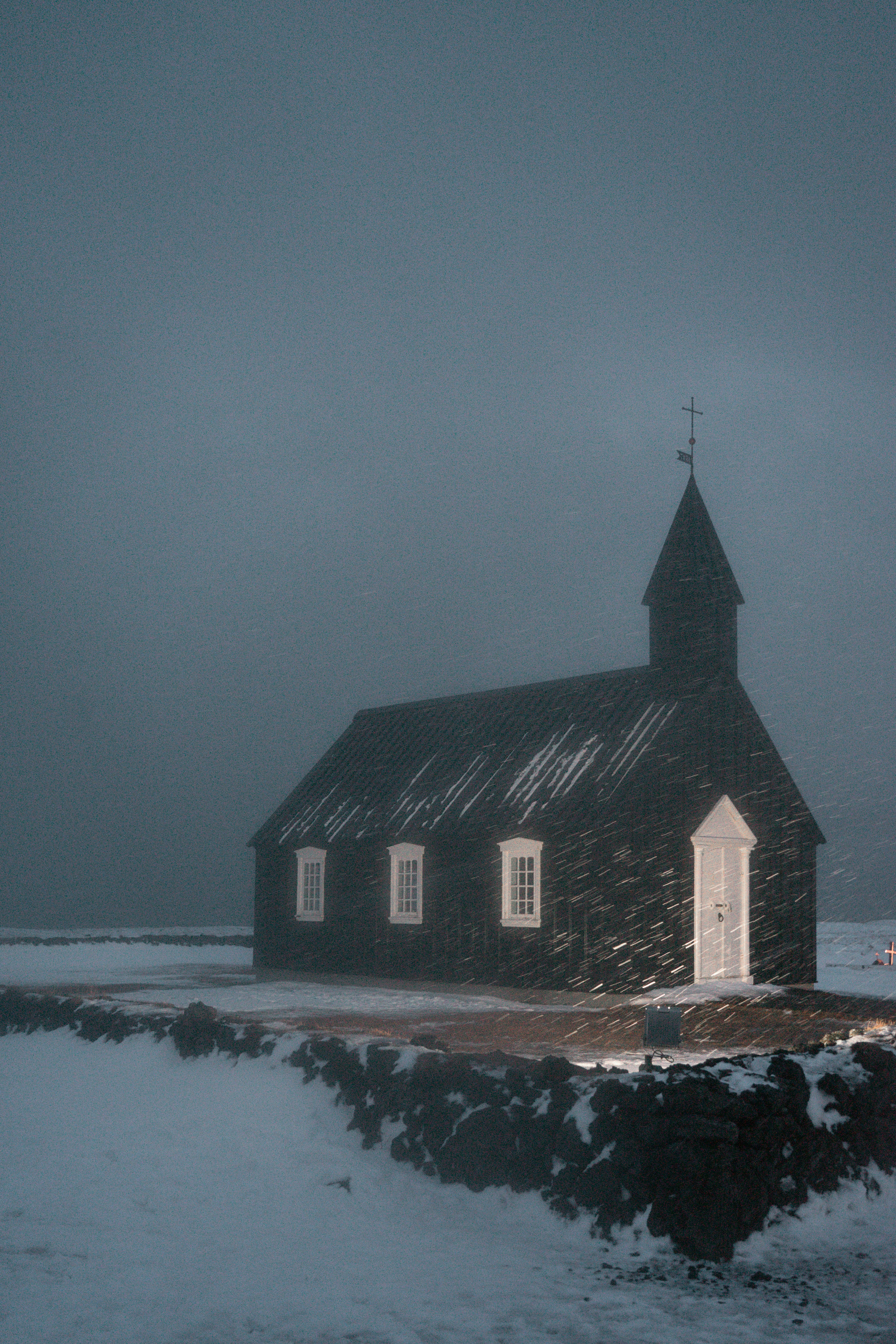 A small church in the middle of a snowy field