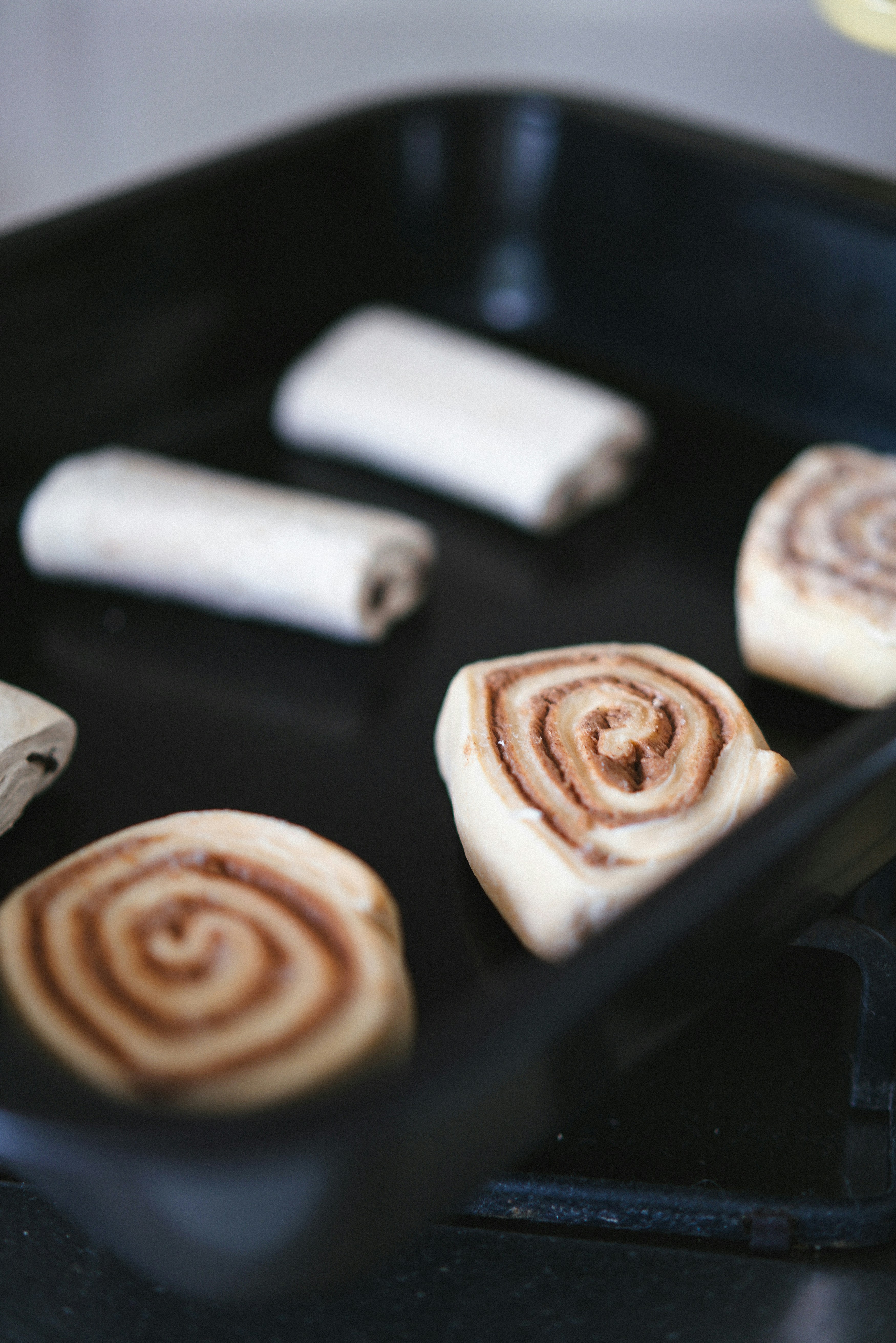 A pan filled with cinnamon rolls on top of a stove