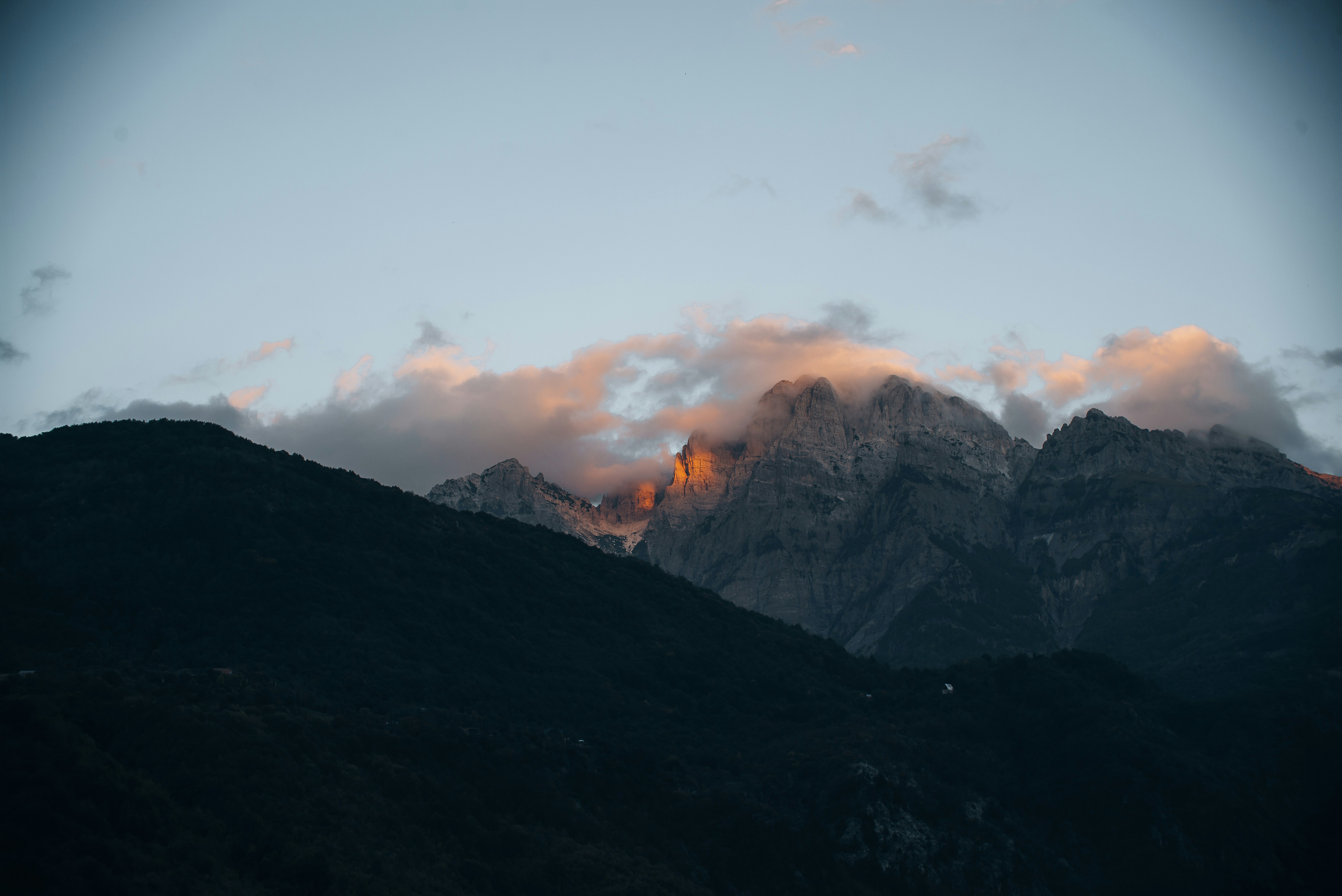 A view of a mountain range with clouds in the sky