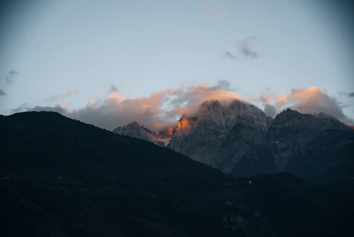 Mountain ridge piercing through low clouds at golden hour