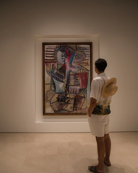 A man looking at a painting in a museum