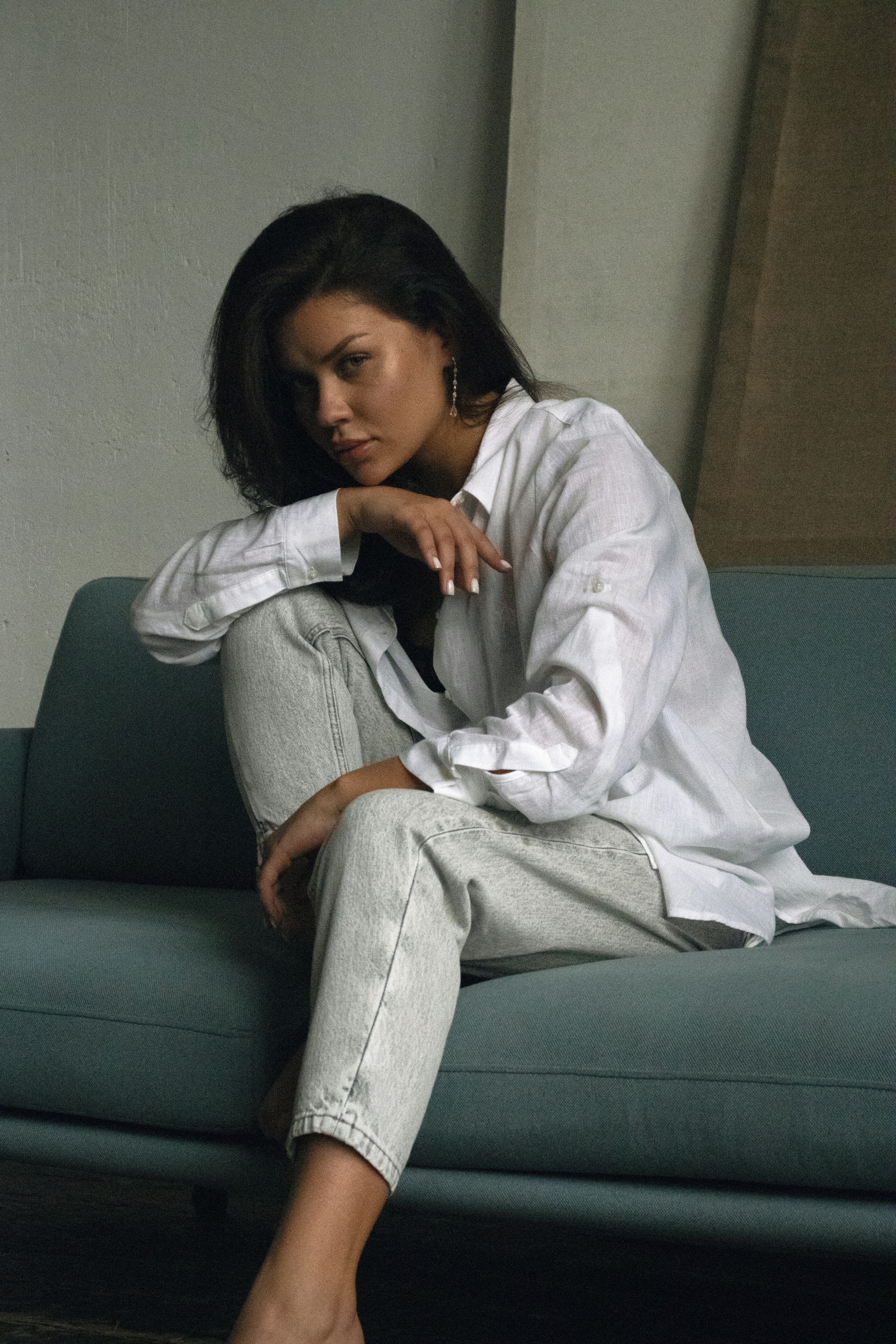 A woman sitting on a couch with her legs crossed