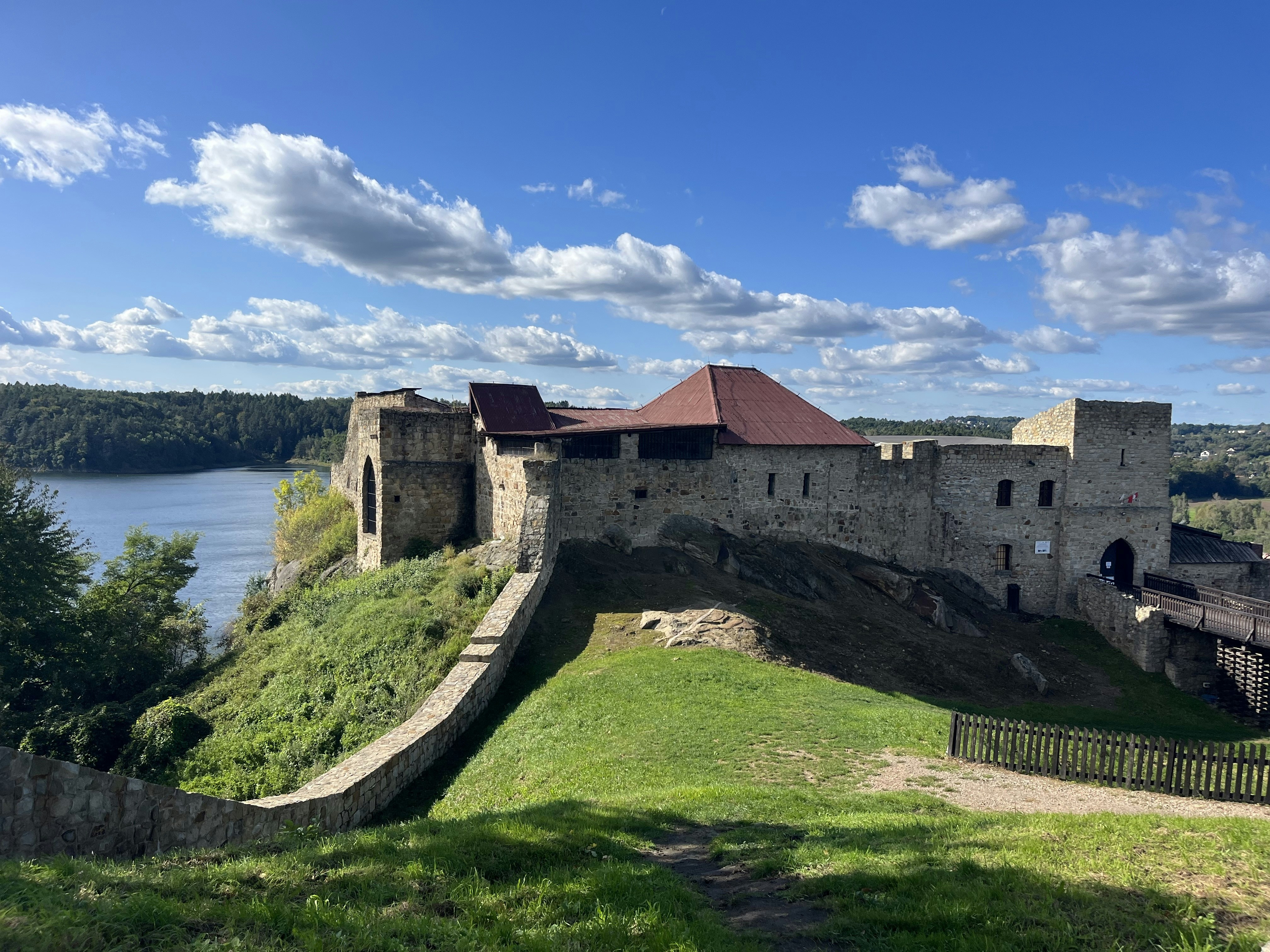 A majestic stone castle on a hill under a blue sky, showcasing historical architecture and scenic views.