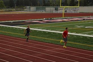 Two men running on a track in a stadium