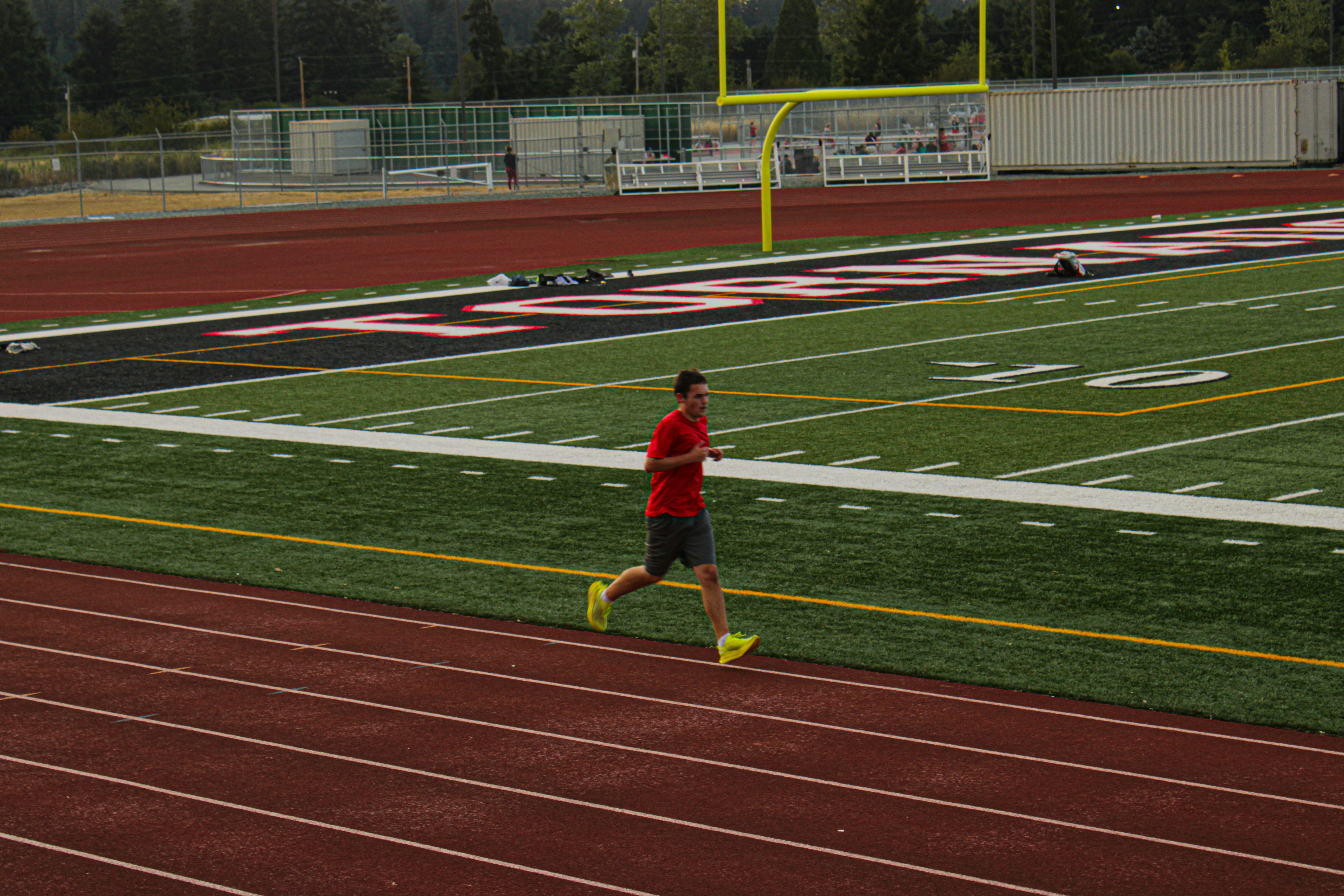 A man in a red shirt running on a track