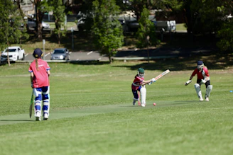 A group of people playing a game of cricket