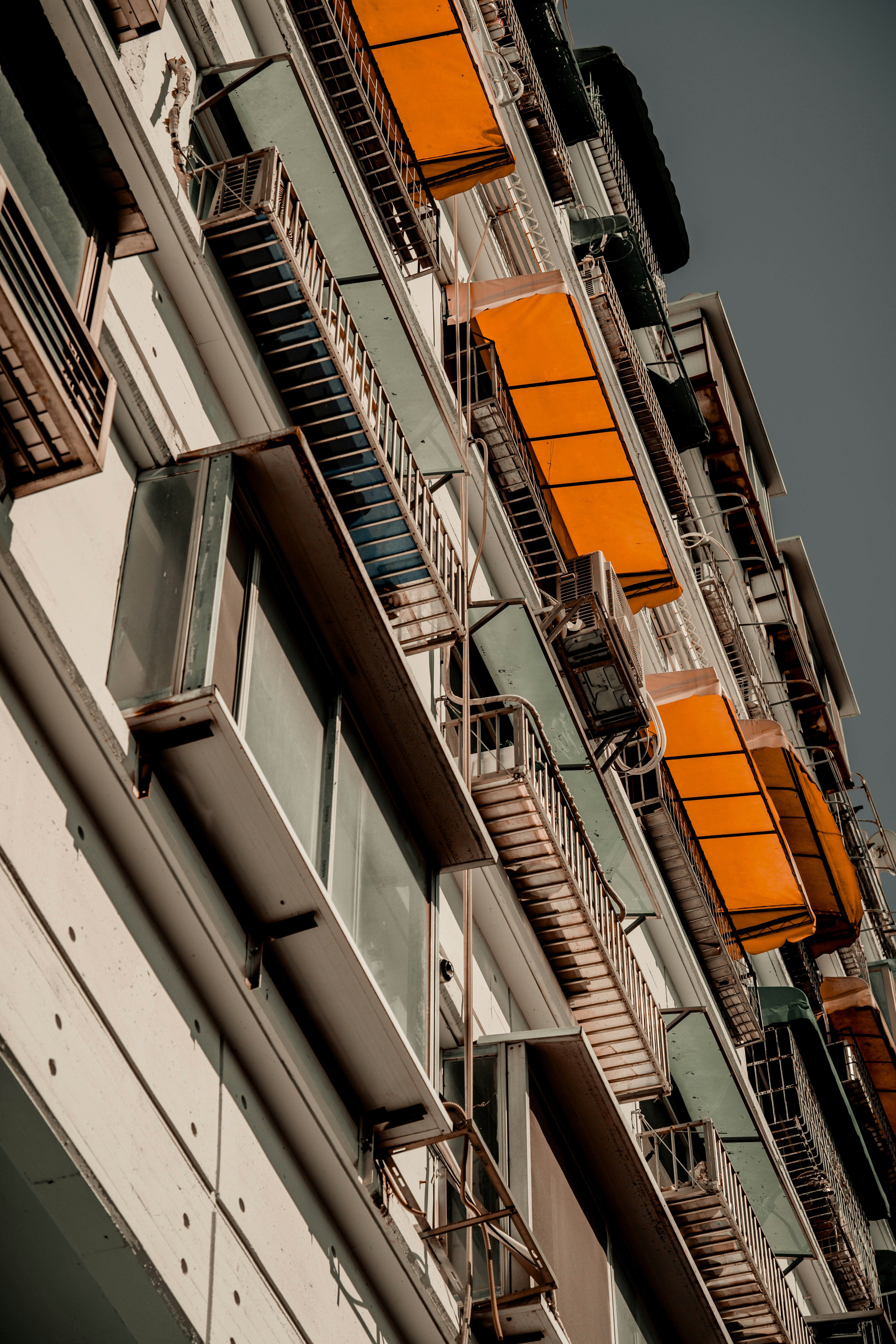 A tall building with balconies and orange balconies