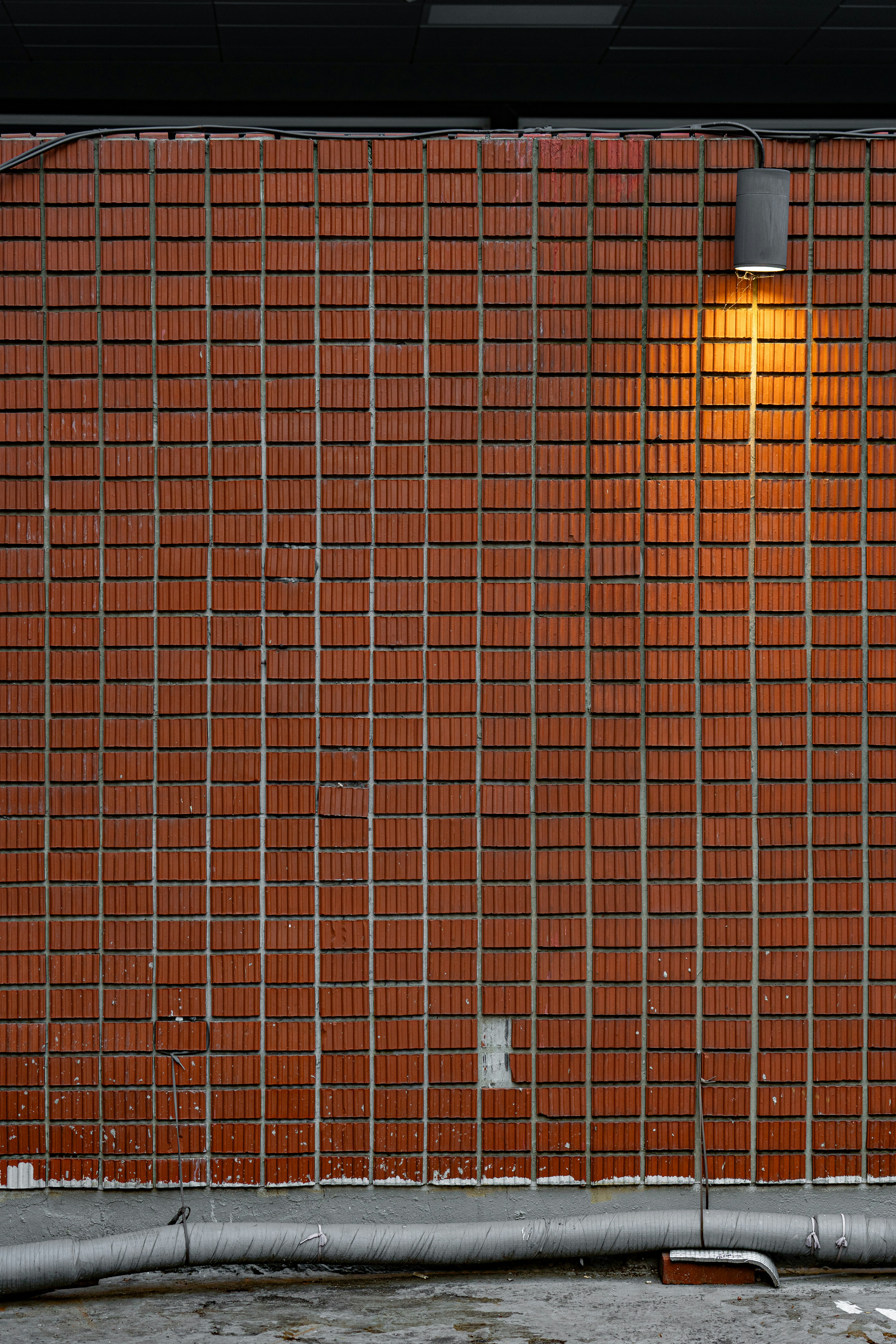 A fire hydrant in front of a red brick wall