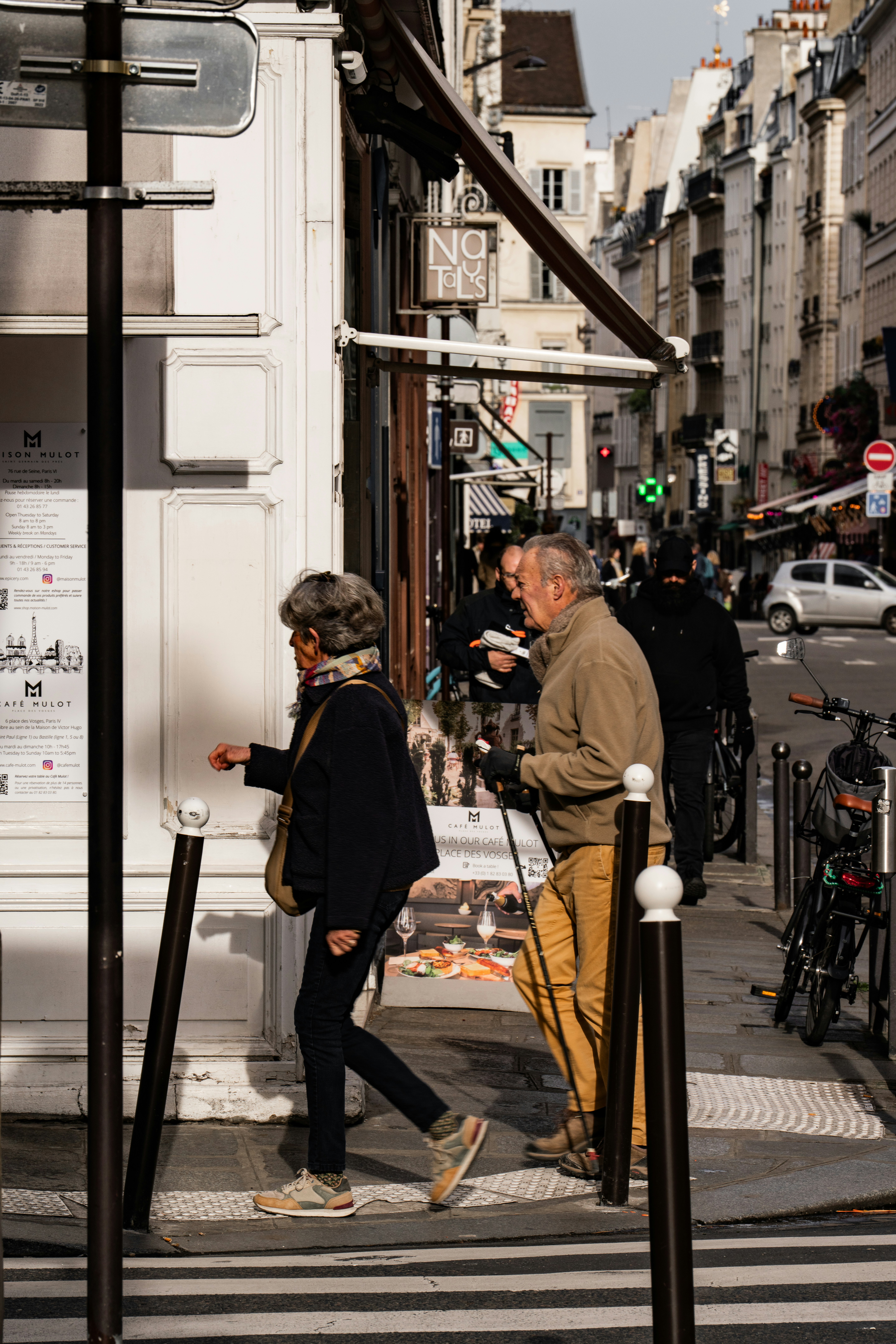 A couple of people that are standing on a sidewalk