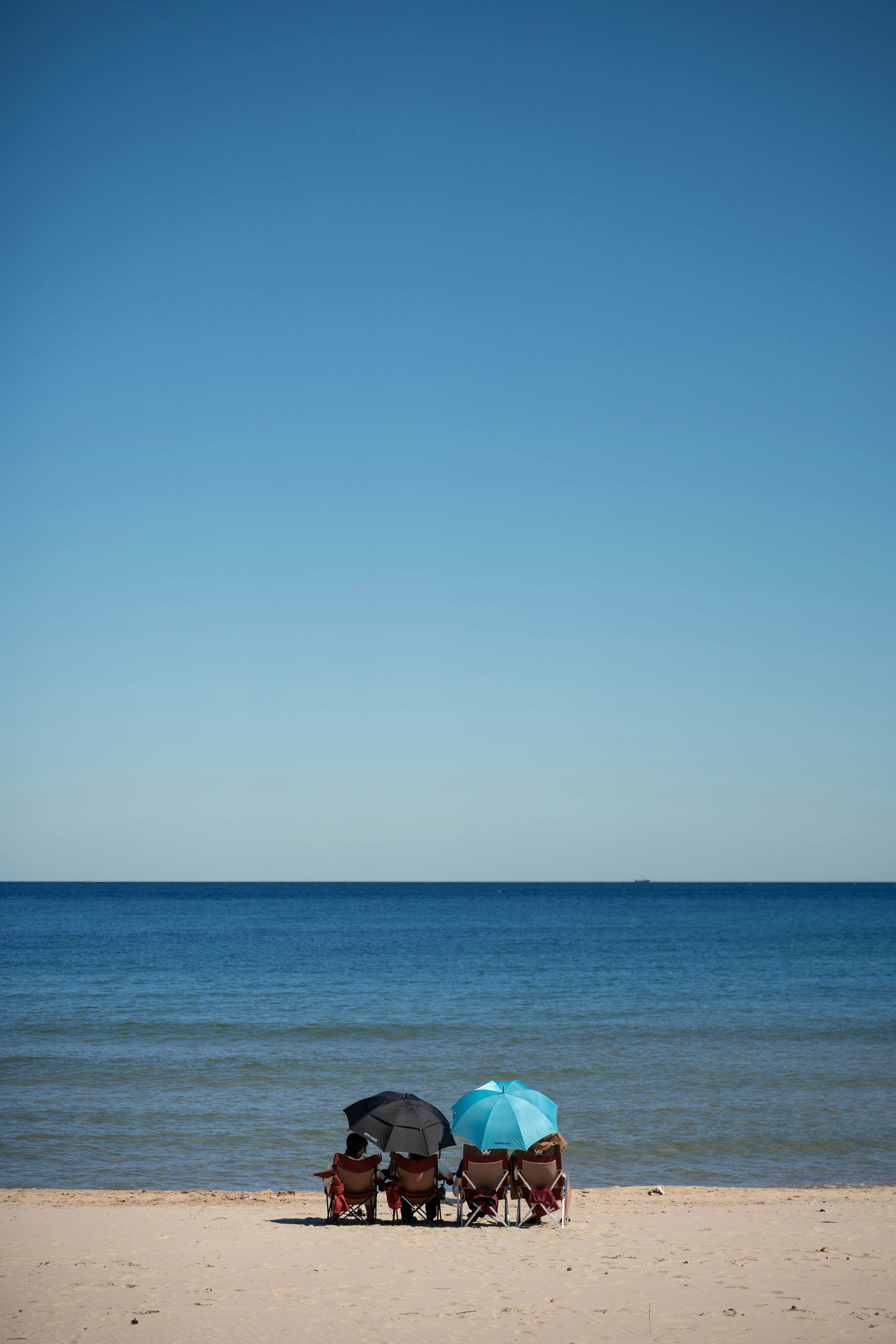 A couple of umbrellas sitting on top of a sandy beach