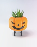 A pumpkin shaped planter with a plant growing out of it