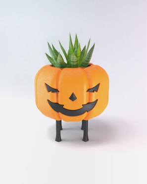 A pumpkin shaped planter with a plant growing out of it