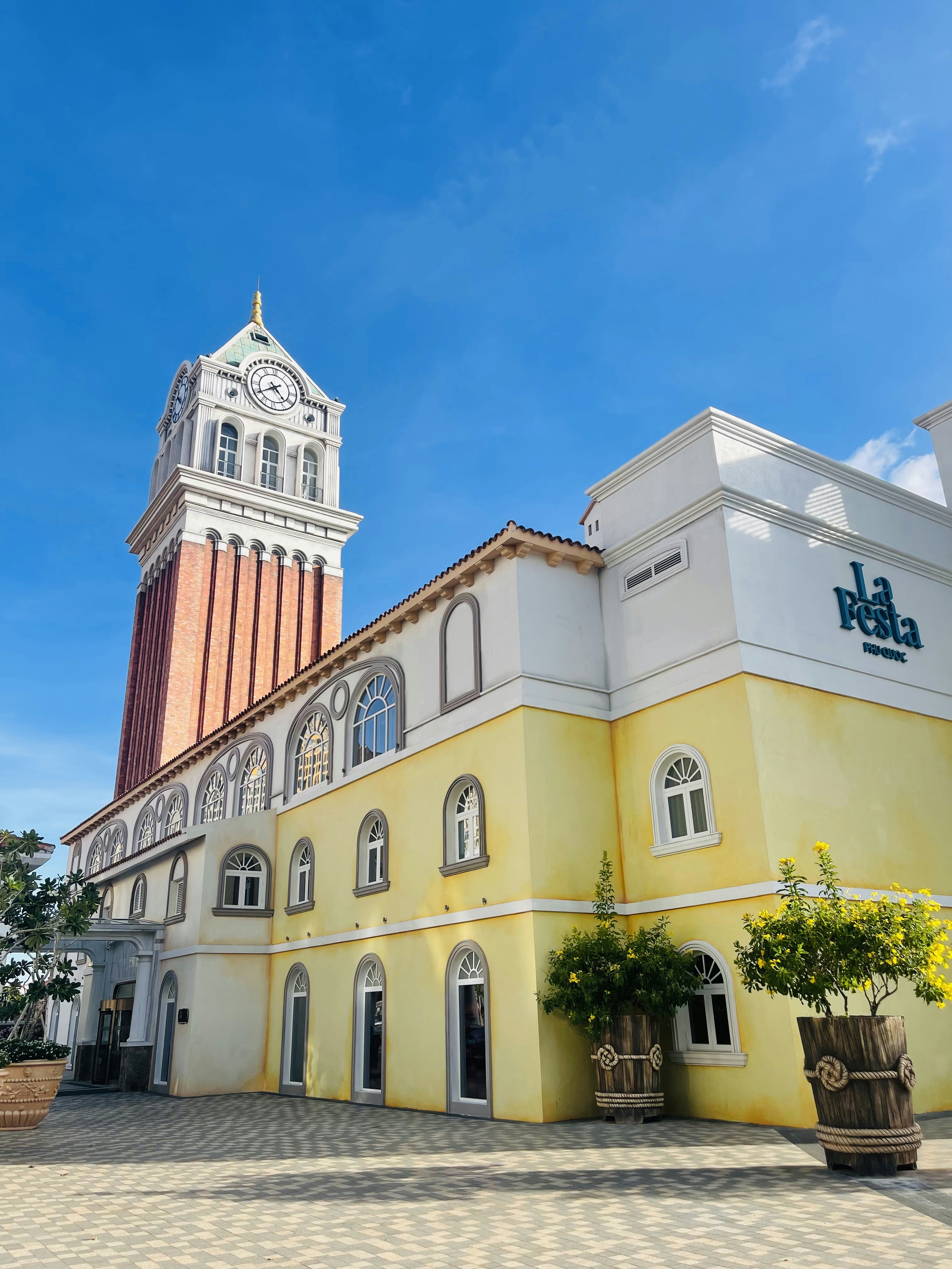 A large yellow building with a clock tower in the background