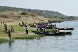 A group of people standing next to a body of water