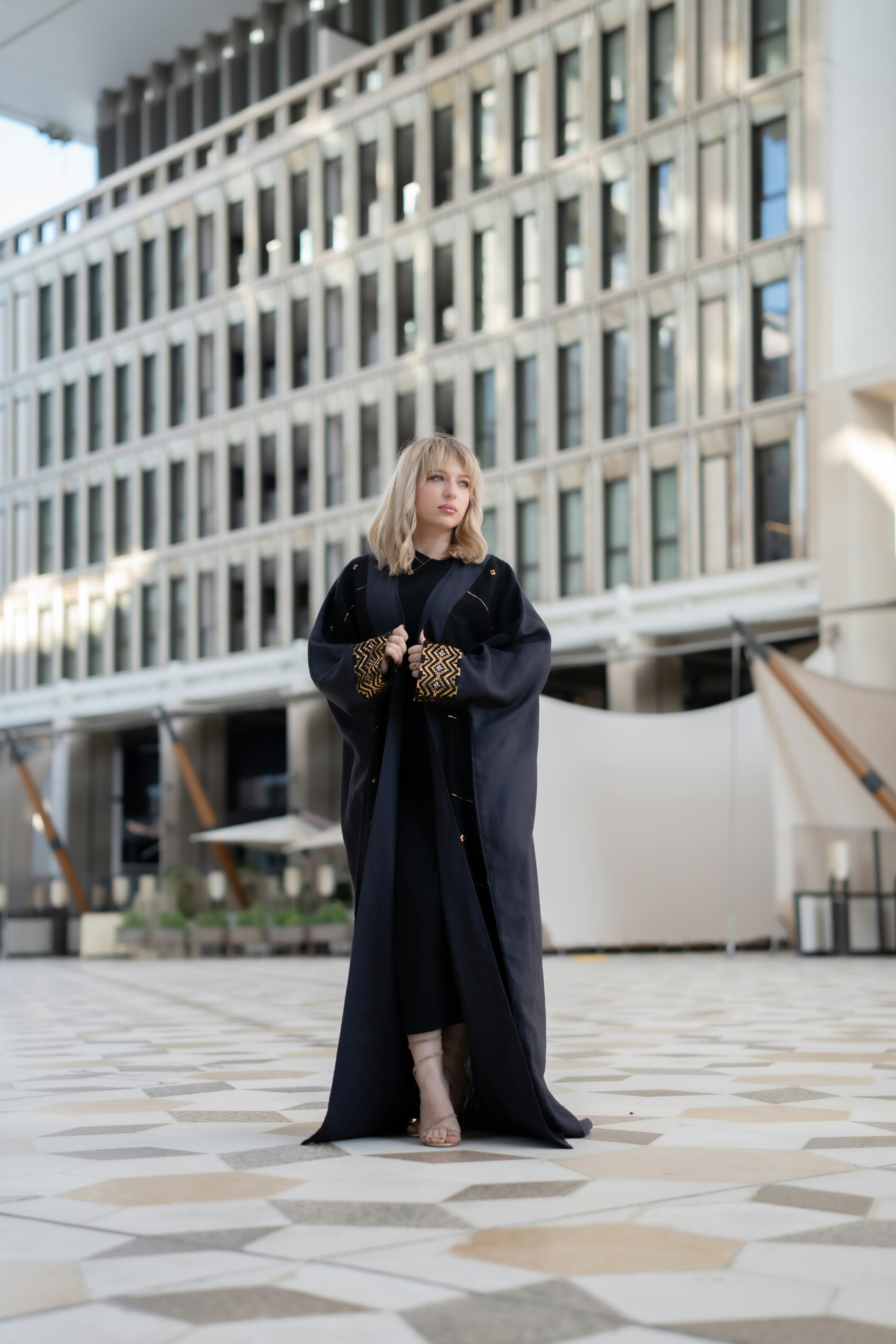 Confident woman in vibrant African-print abaya with bold colors and modern styling