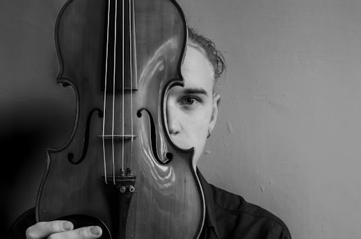 A man holding a violin in front of his face