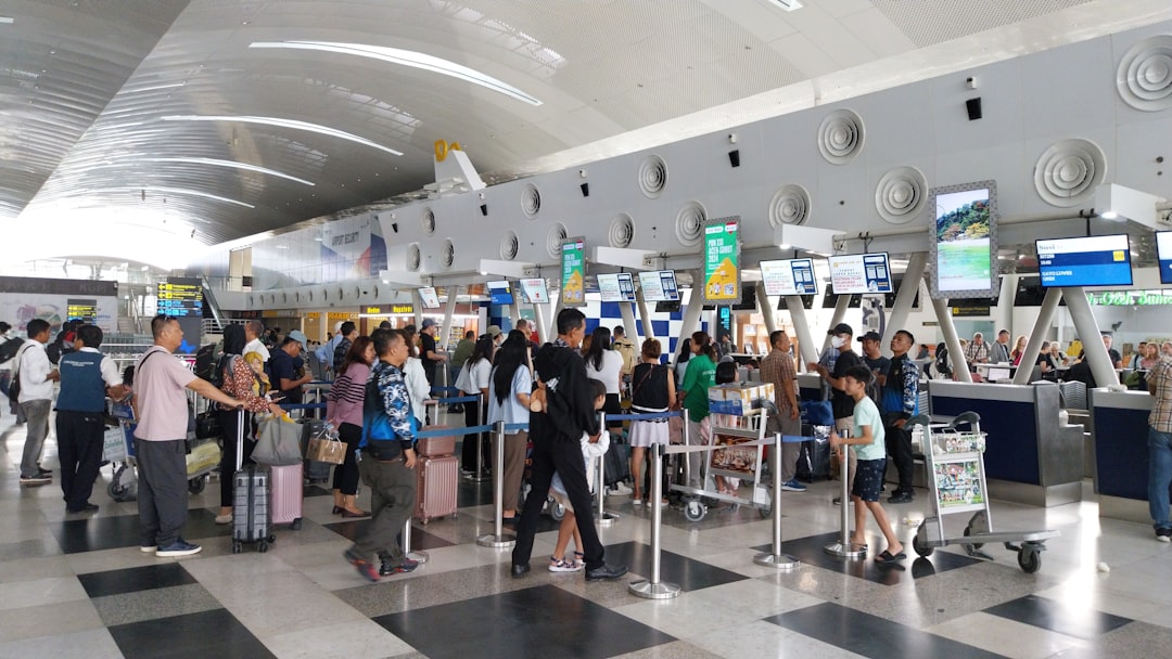 A large group of people waiting in line at an airport, Queue at Airport Check In Counters of Kualanamu International Air