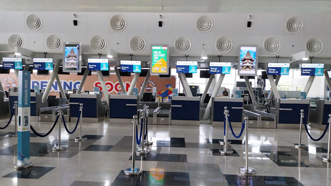 An airport with a lot of luggage and check in counters