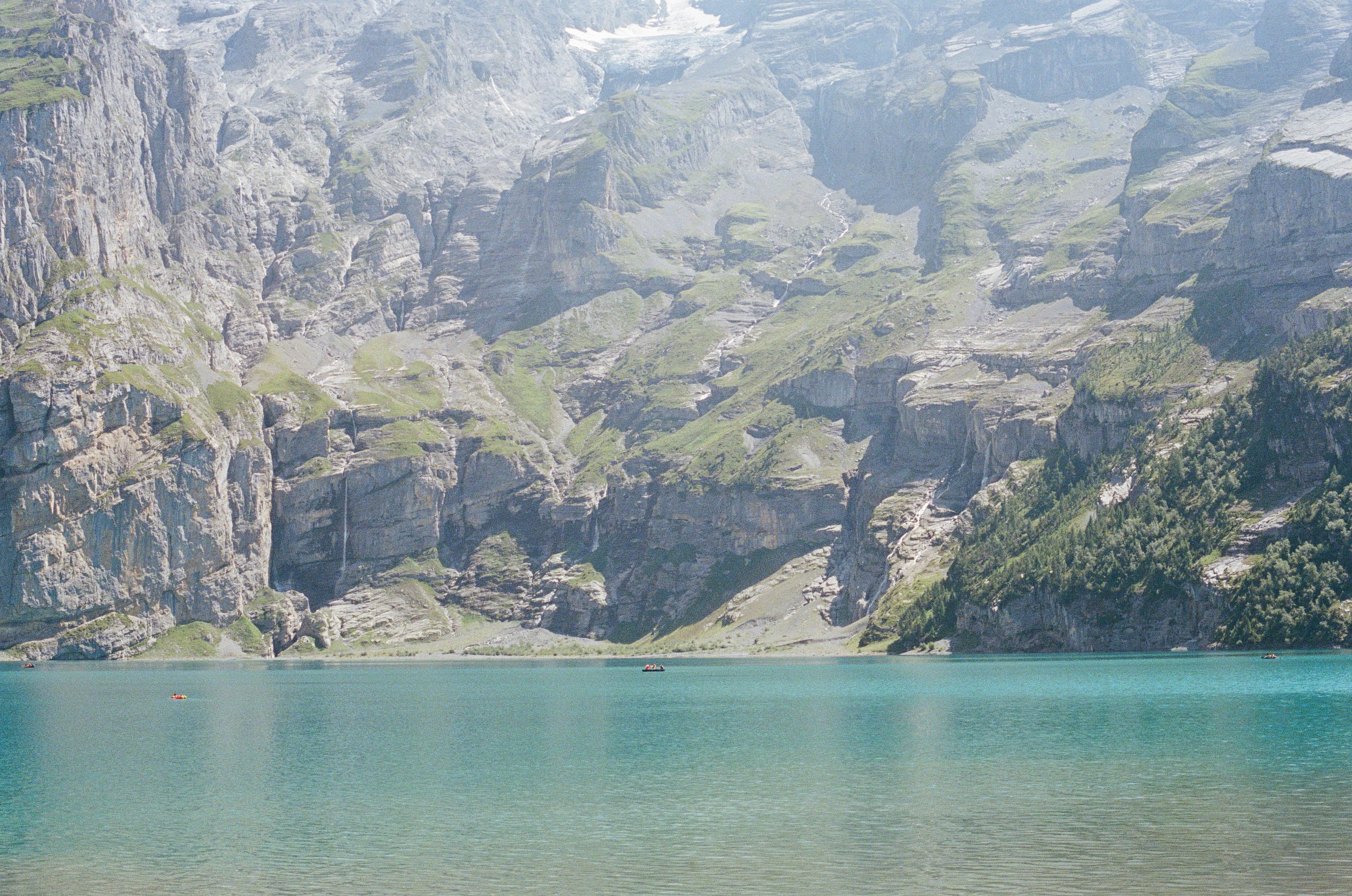 A boat floating on a lake surrounded by mountains