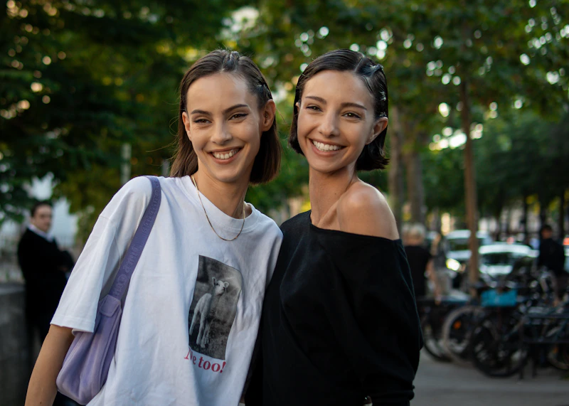 两位时尚女性并肩走在人行道上