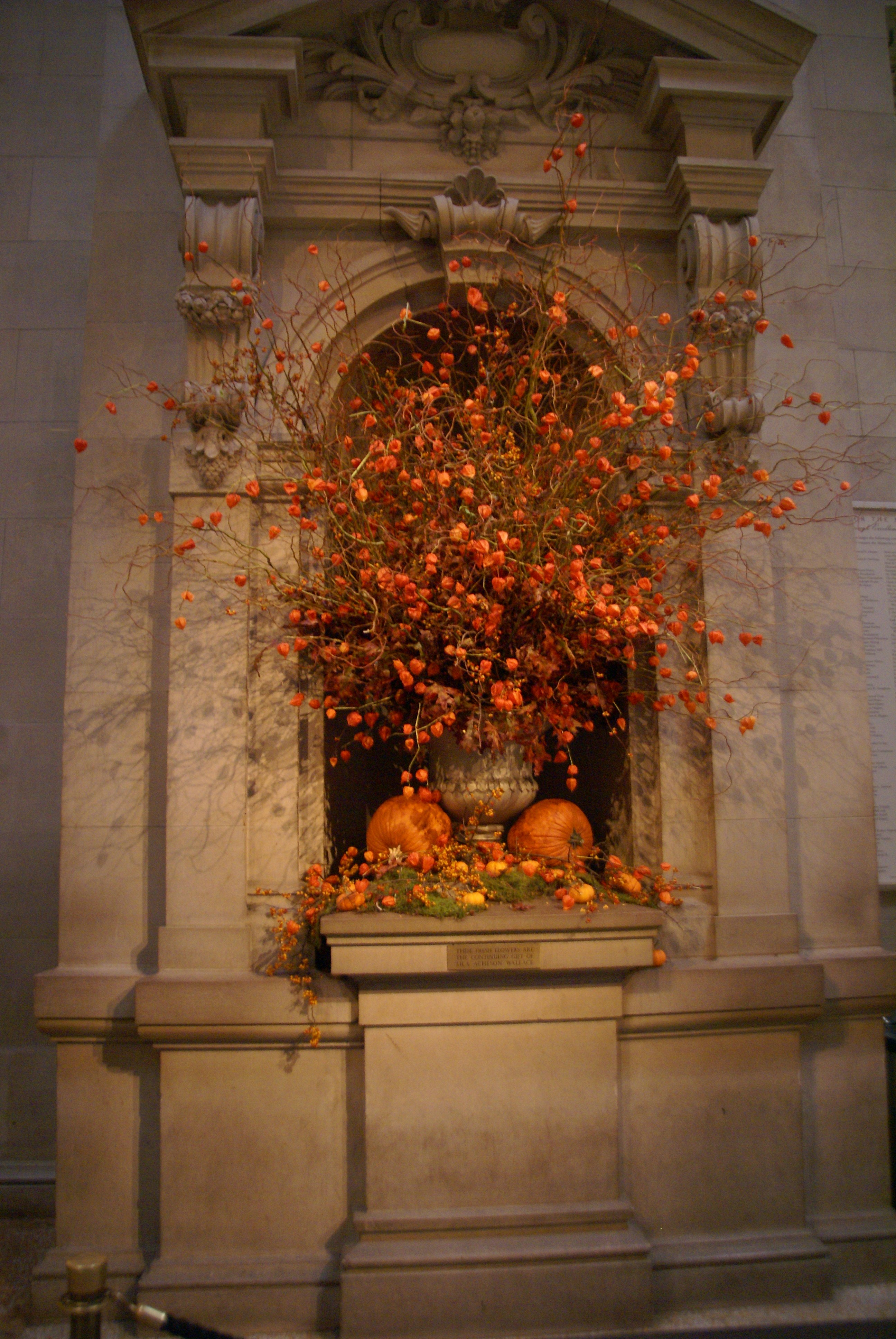 A vase filled with lots of orange flowers