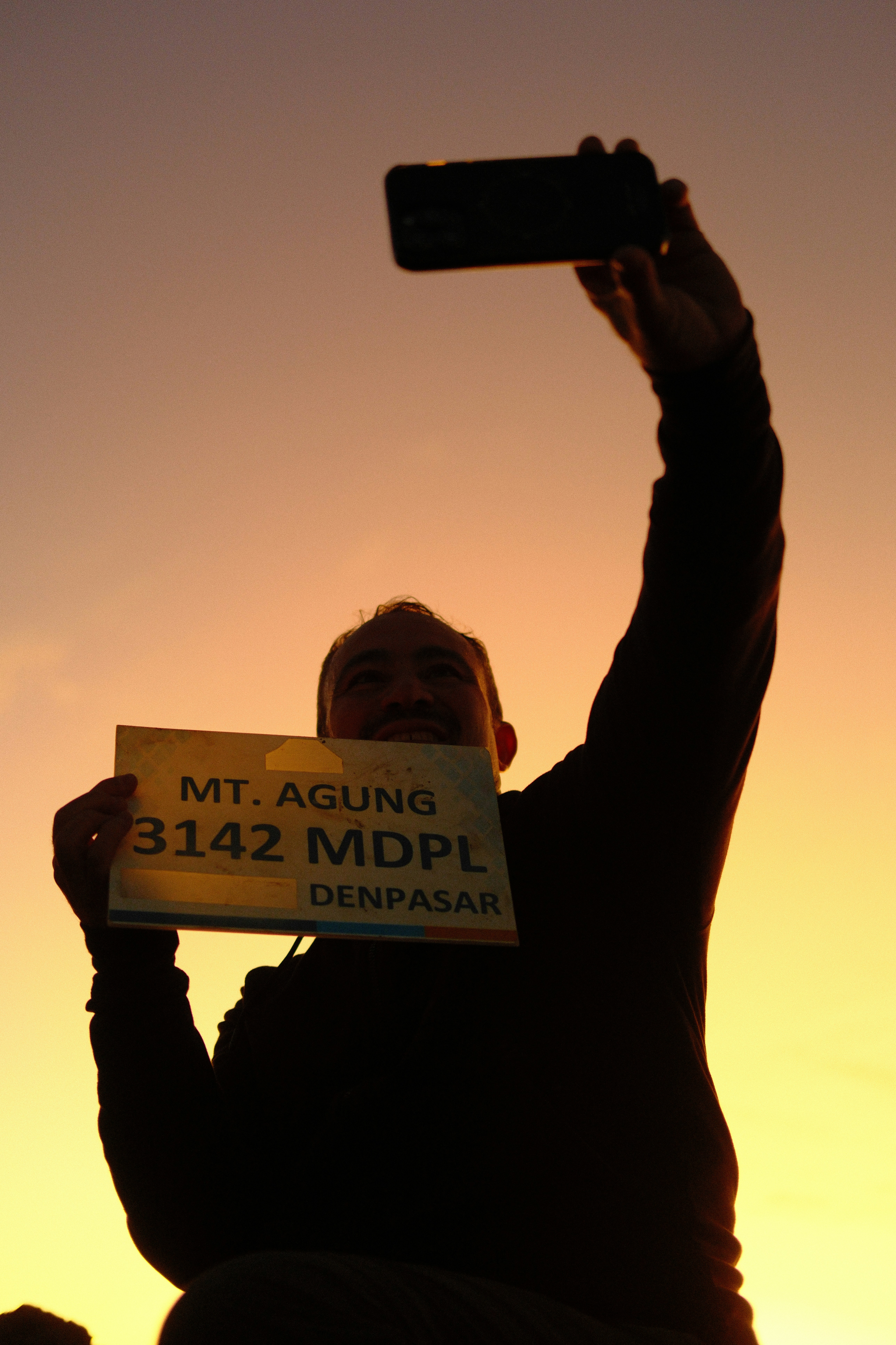 A man holding a cell phone up in the air