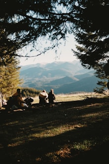 A group of people sitting on top of a grass covered field
