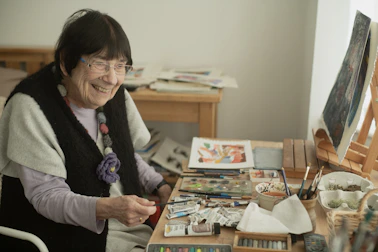 A woman sitting in a chair in front of a wooden table